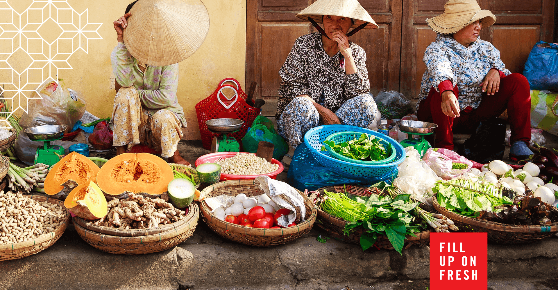 A group of women are sitting at a market selling vegetables.
