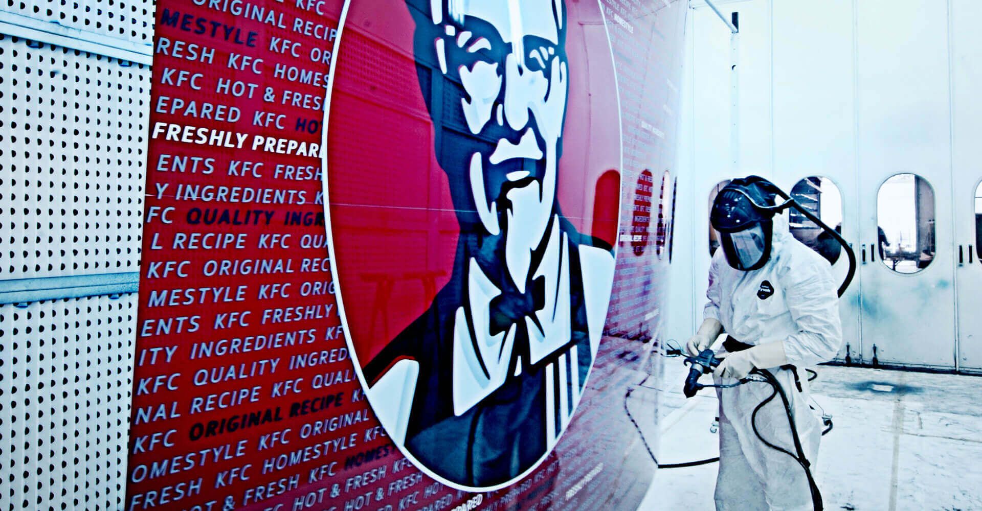 A man is painting a mural of a man on a wall.