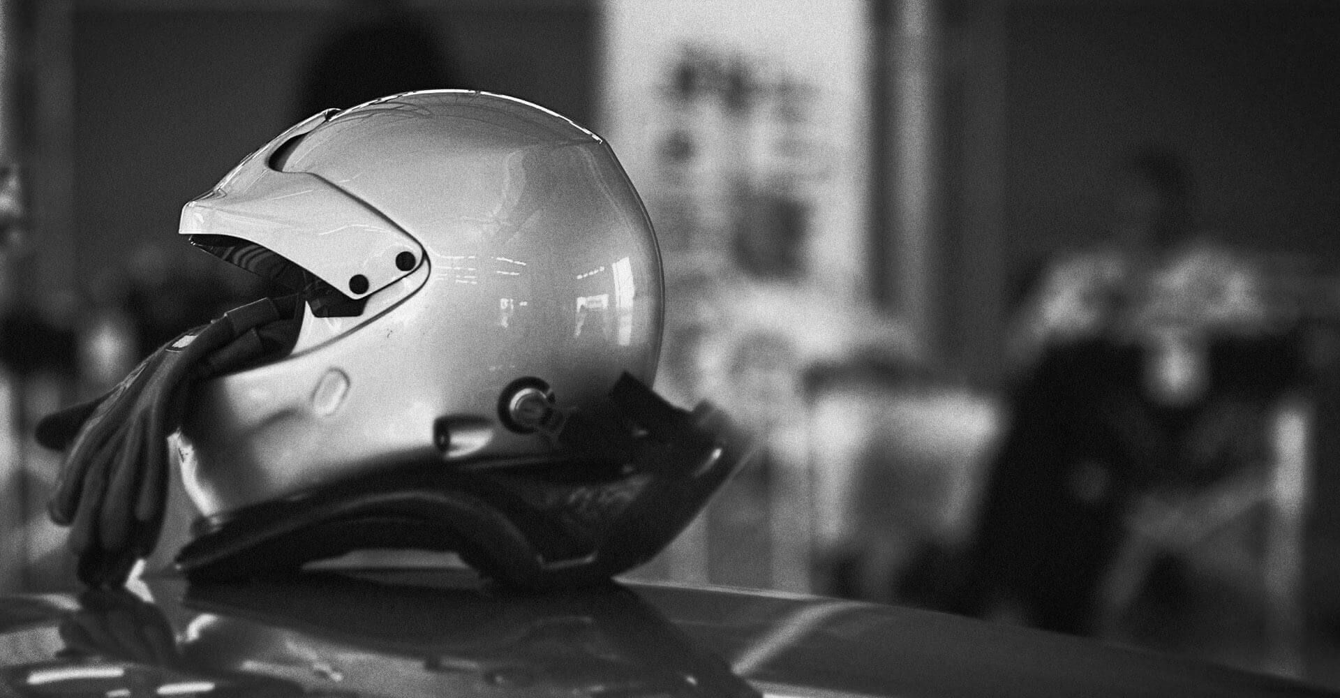 A black and white photo of a motorcycle helmet on top of a car.