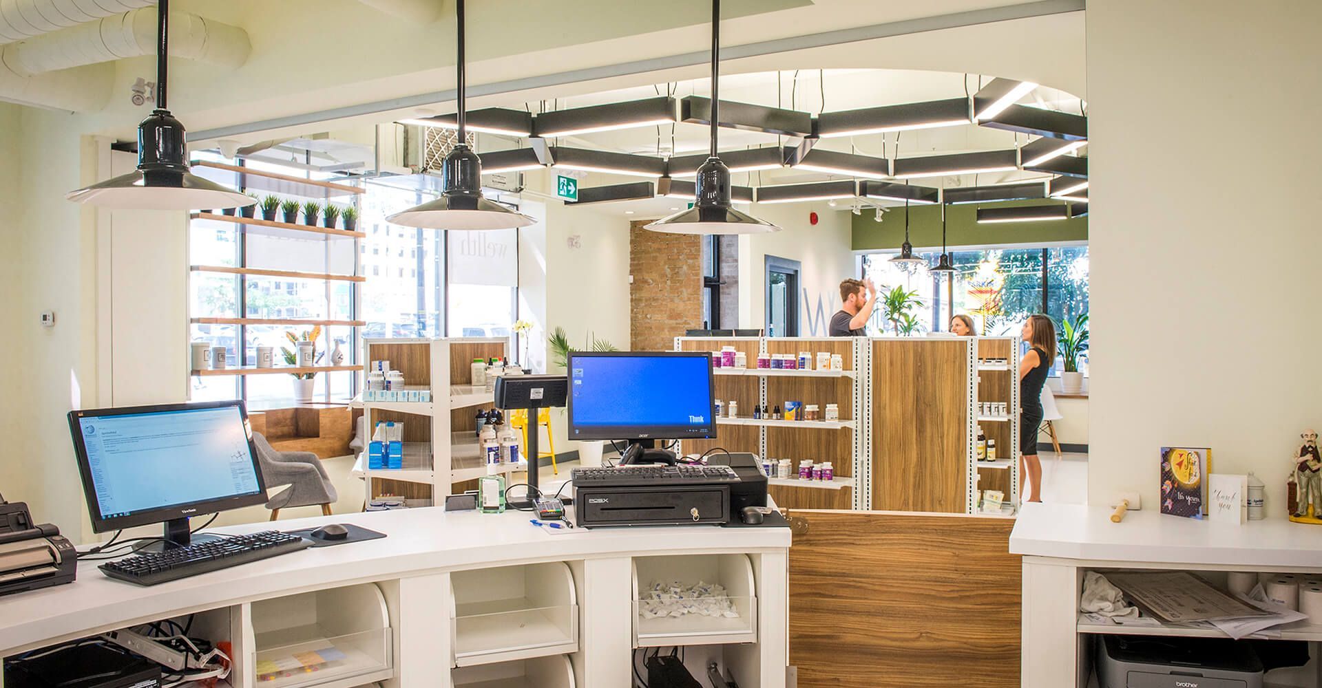 A computer is sitting on a desk in a pharmacy.