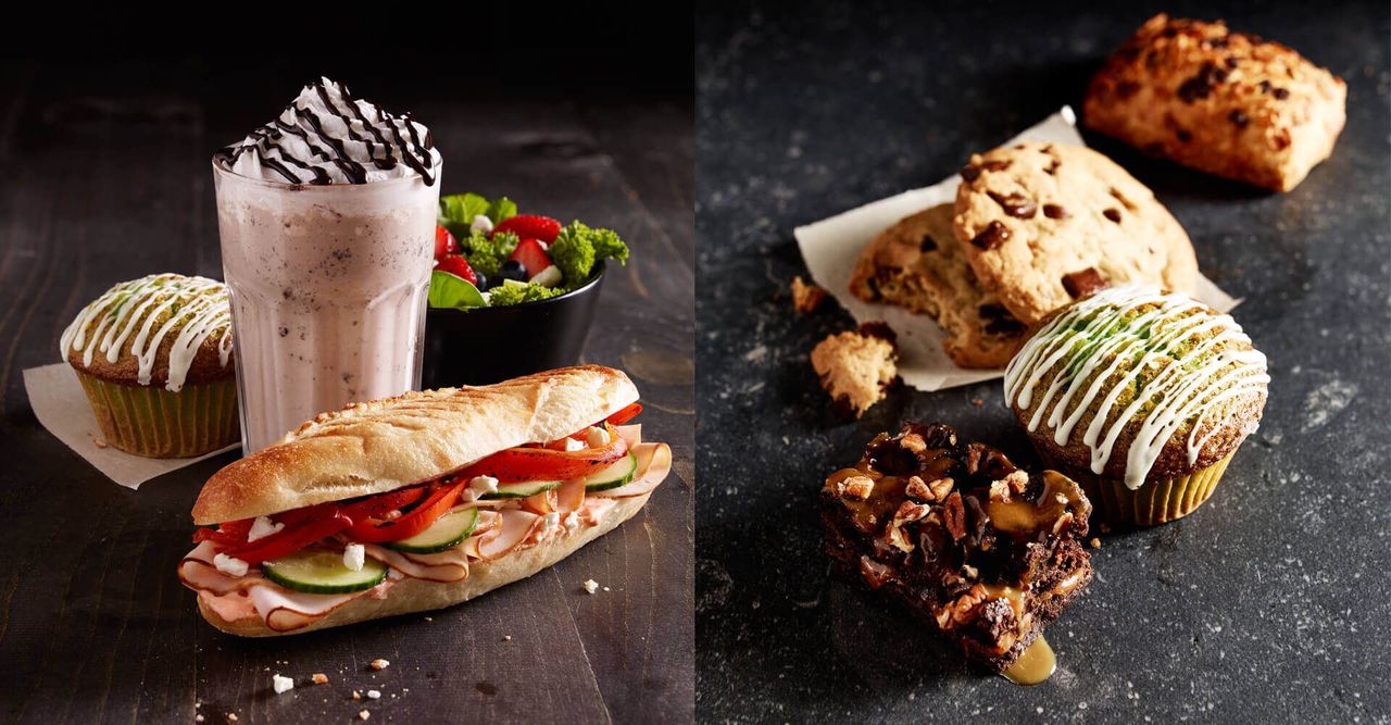 A sandwich and a milkshake are sitting next to each other on a table.