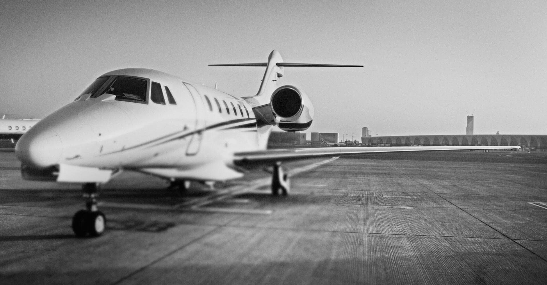 A small private jet is parked on a runway.