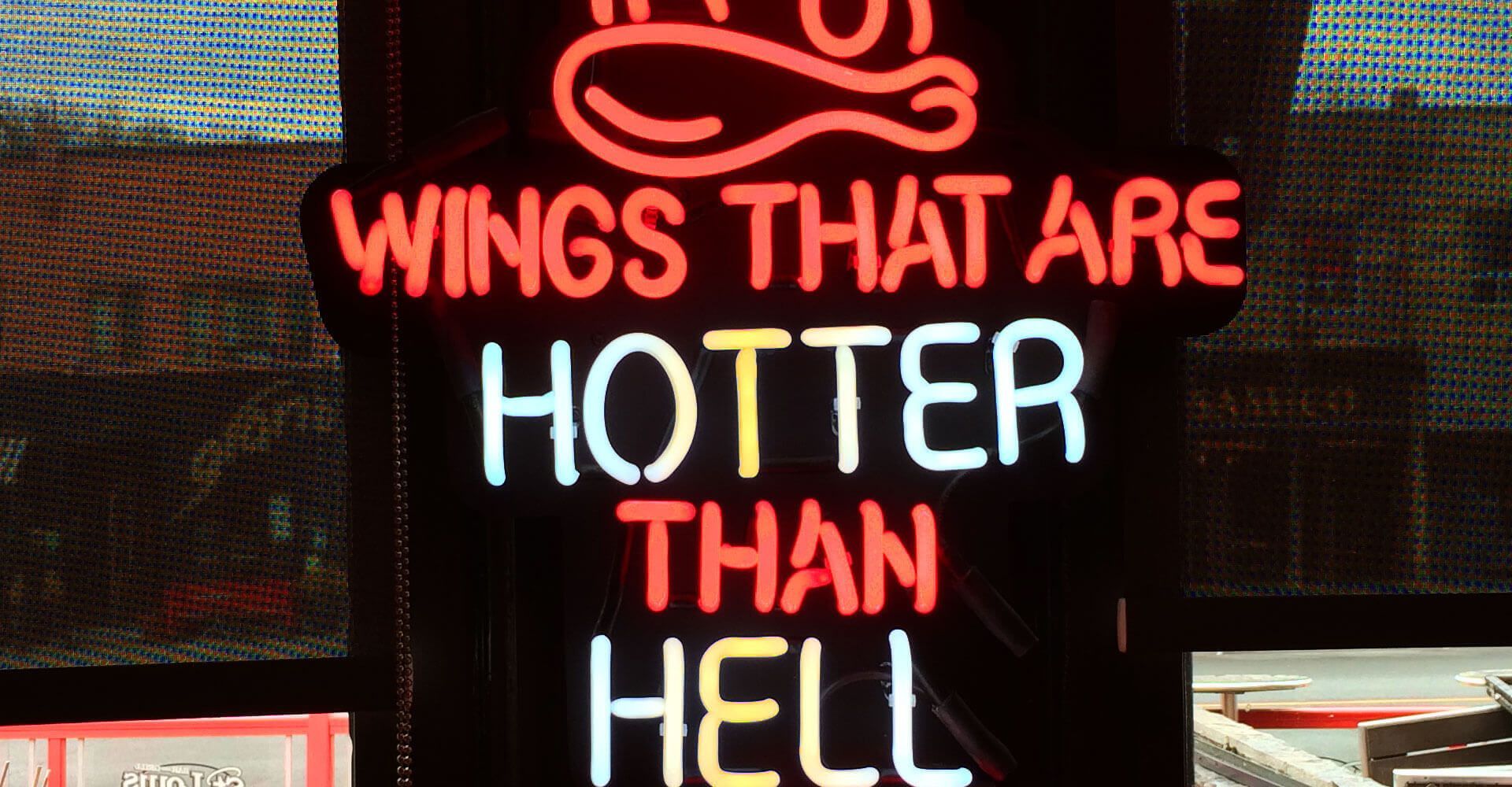 a neon sign that says wings that are hotter than hell