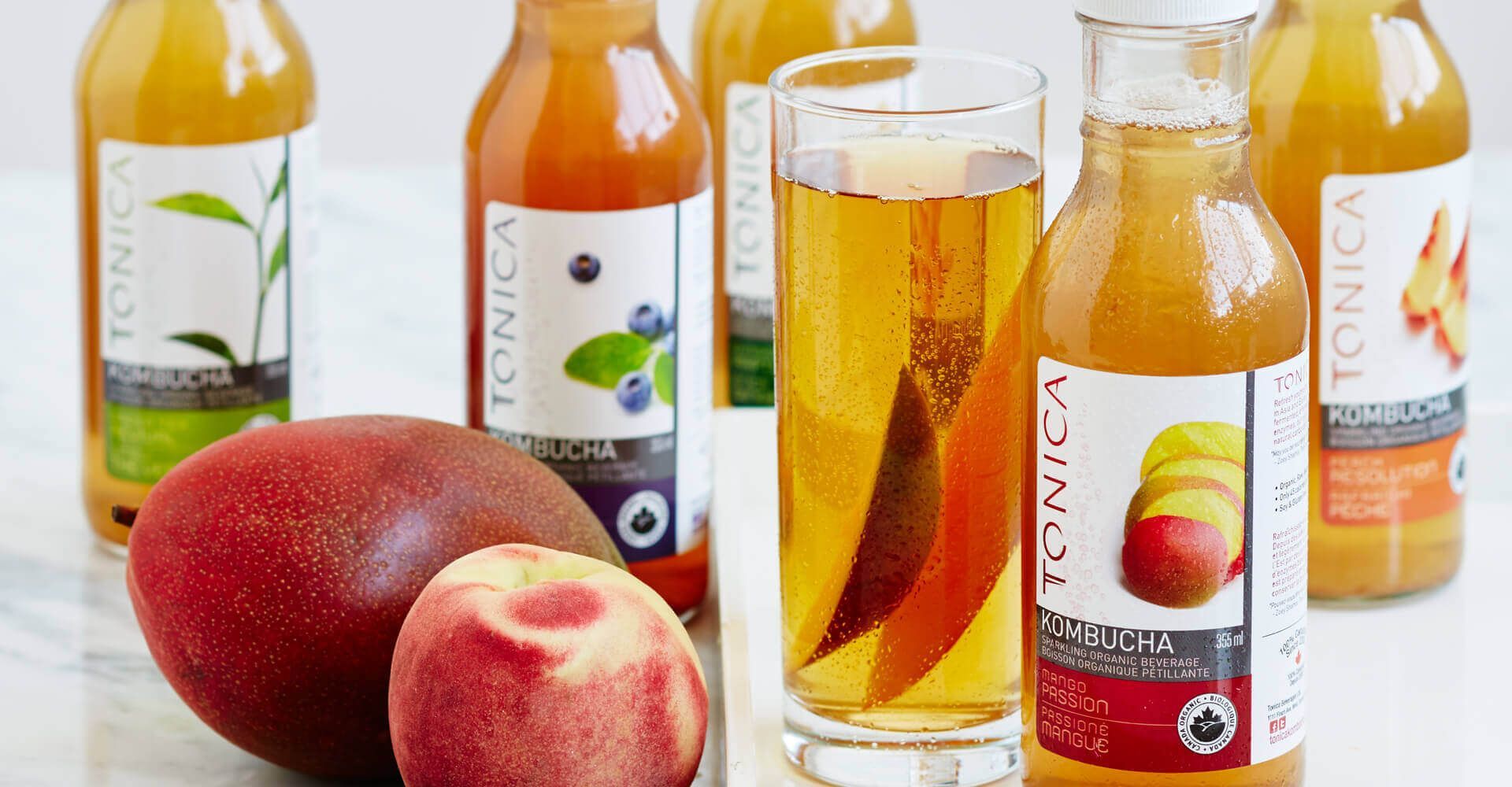 A bottle of tonica juice is next to a glass of tonica juice.