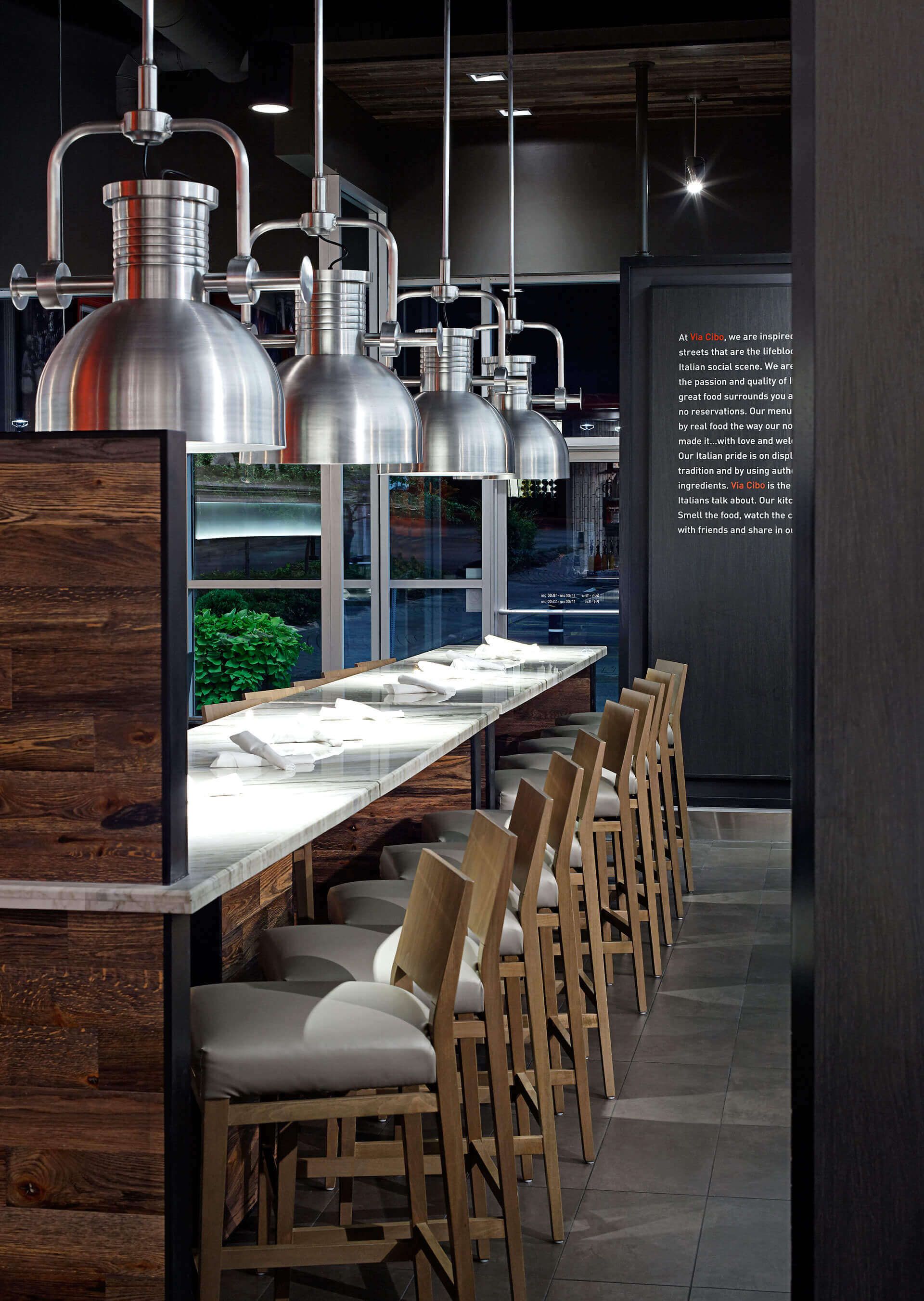A restaurant with a long dining table and stools