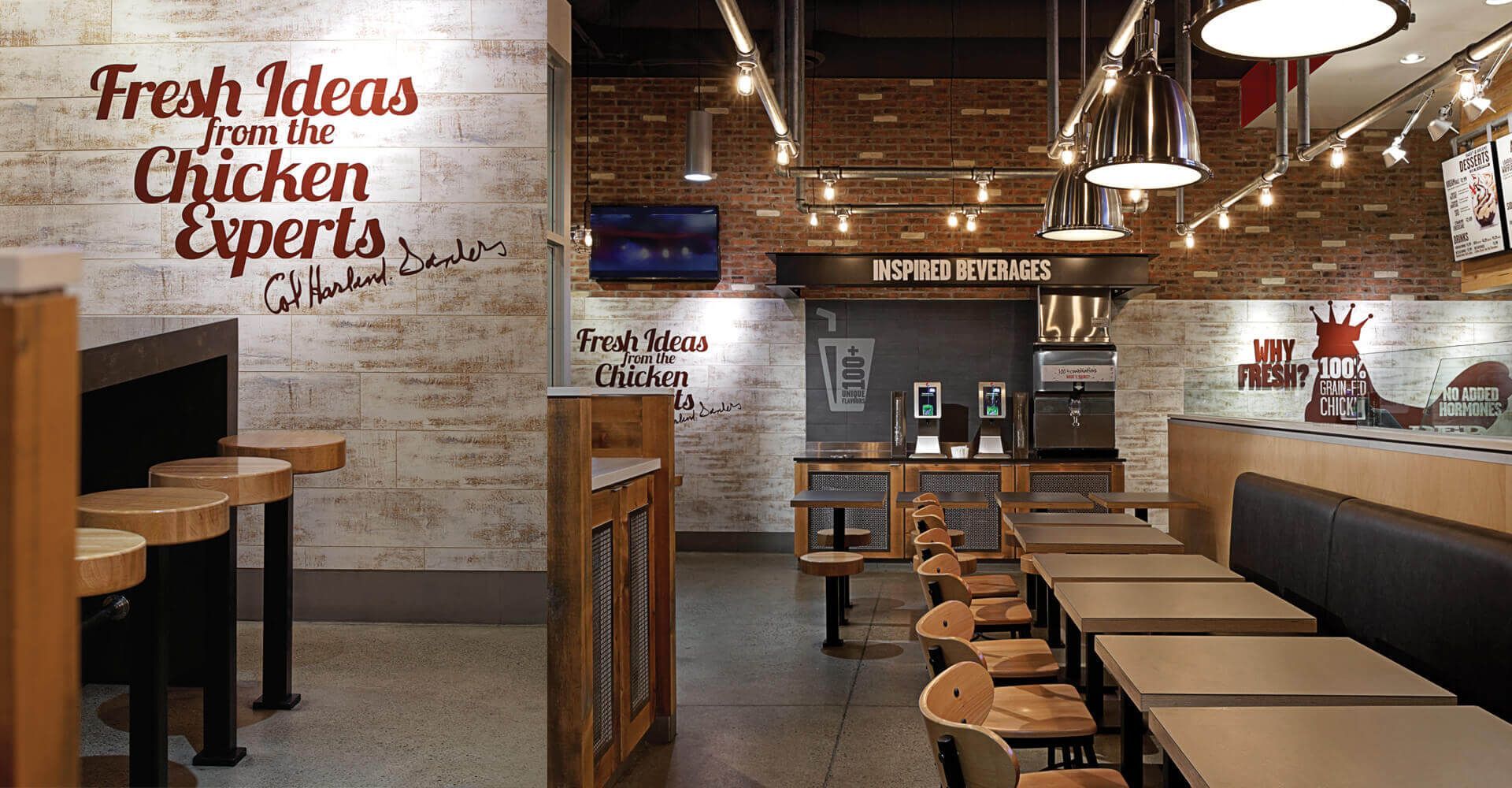 A restaurant with tables and chairs and a sign that says fresh ideas from the chicken experts