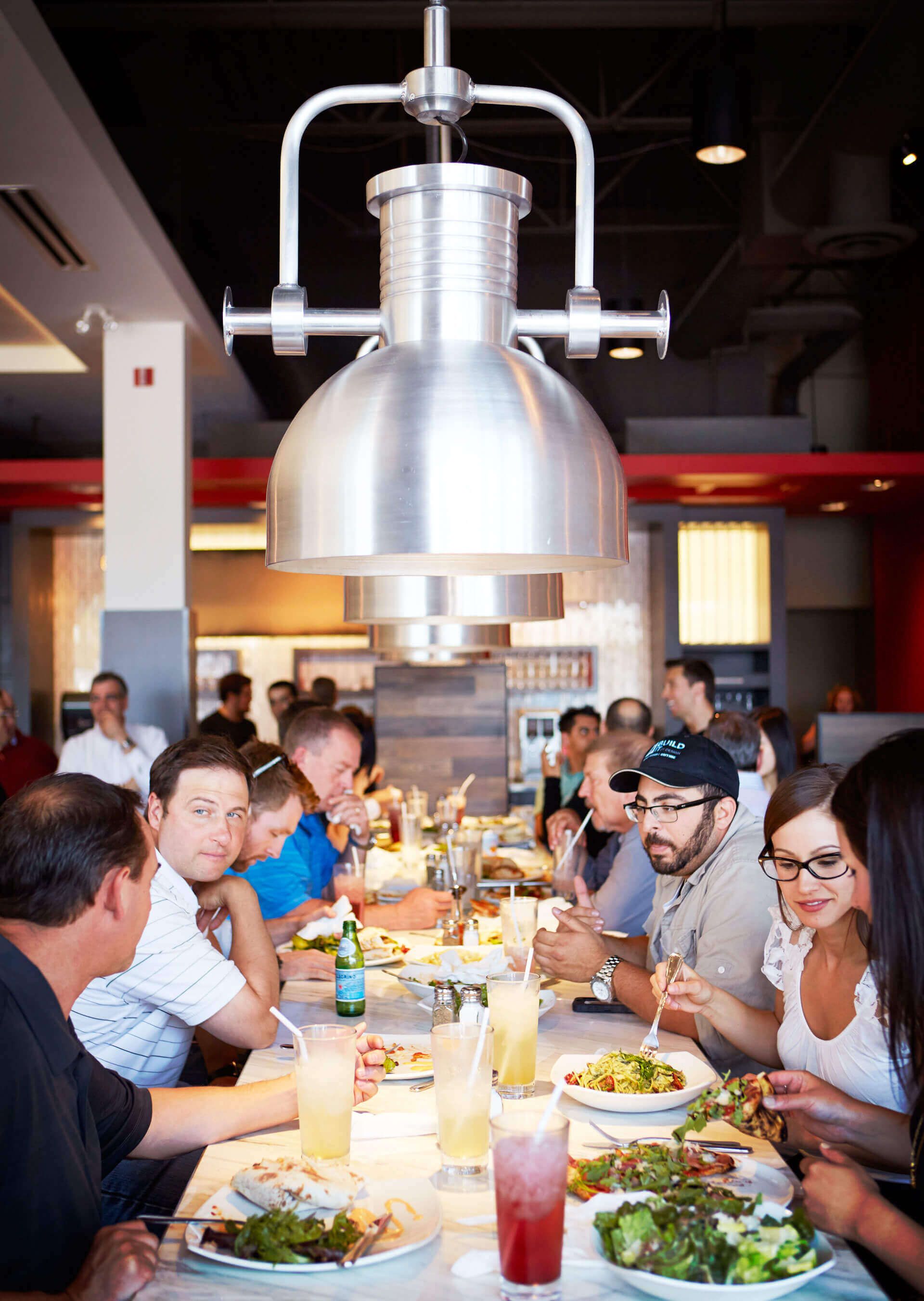 A group of people are sitting at tables in a restaurant eating food.