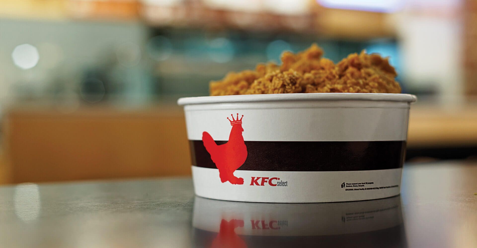A bowl of fried chicken from kfc is on a table.