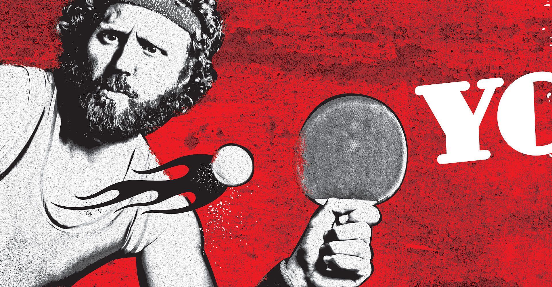 A man with a beard is playing ping pong on a red background
