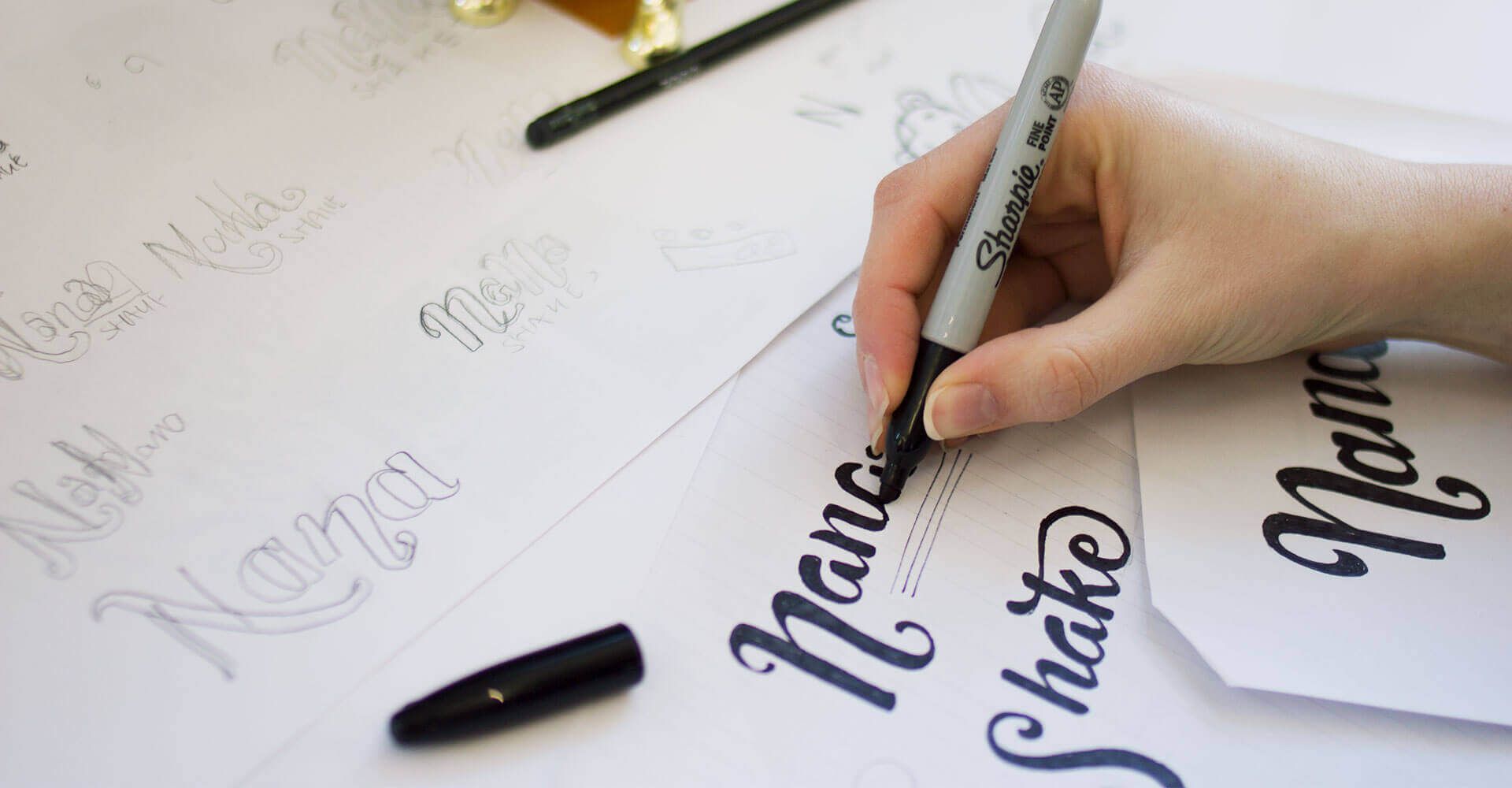 A person is writing on a piece of paper with a marker.