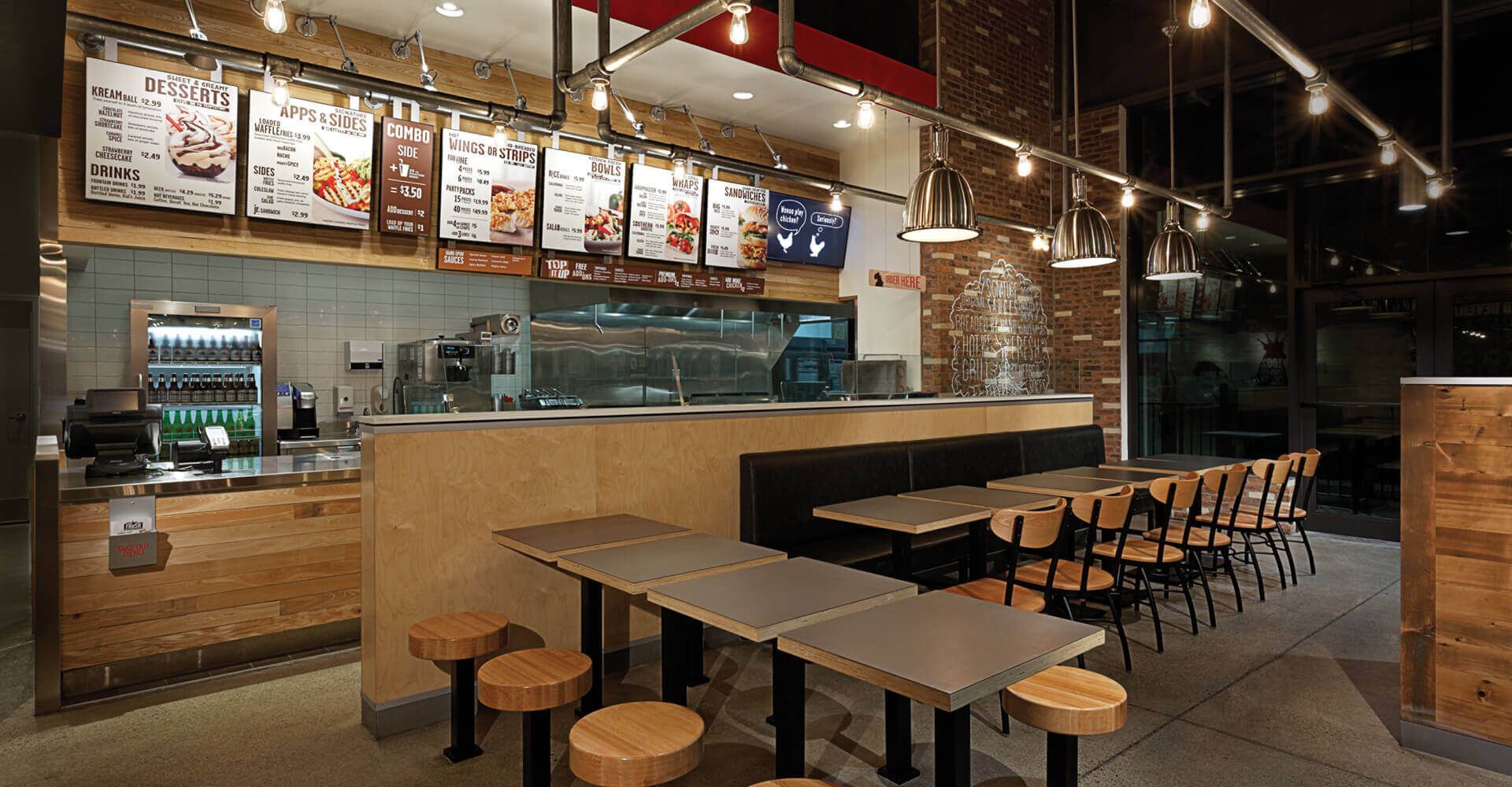 A restaurant with tables and chairs and a counter.