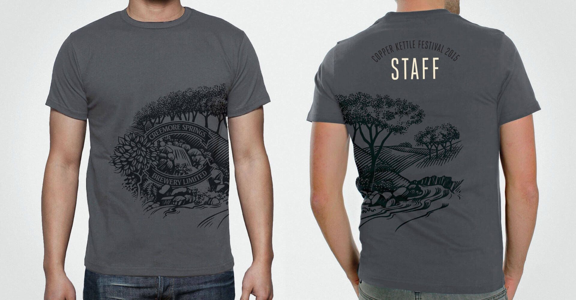 A man is wearing a gray t-shirt with a tree on it.