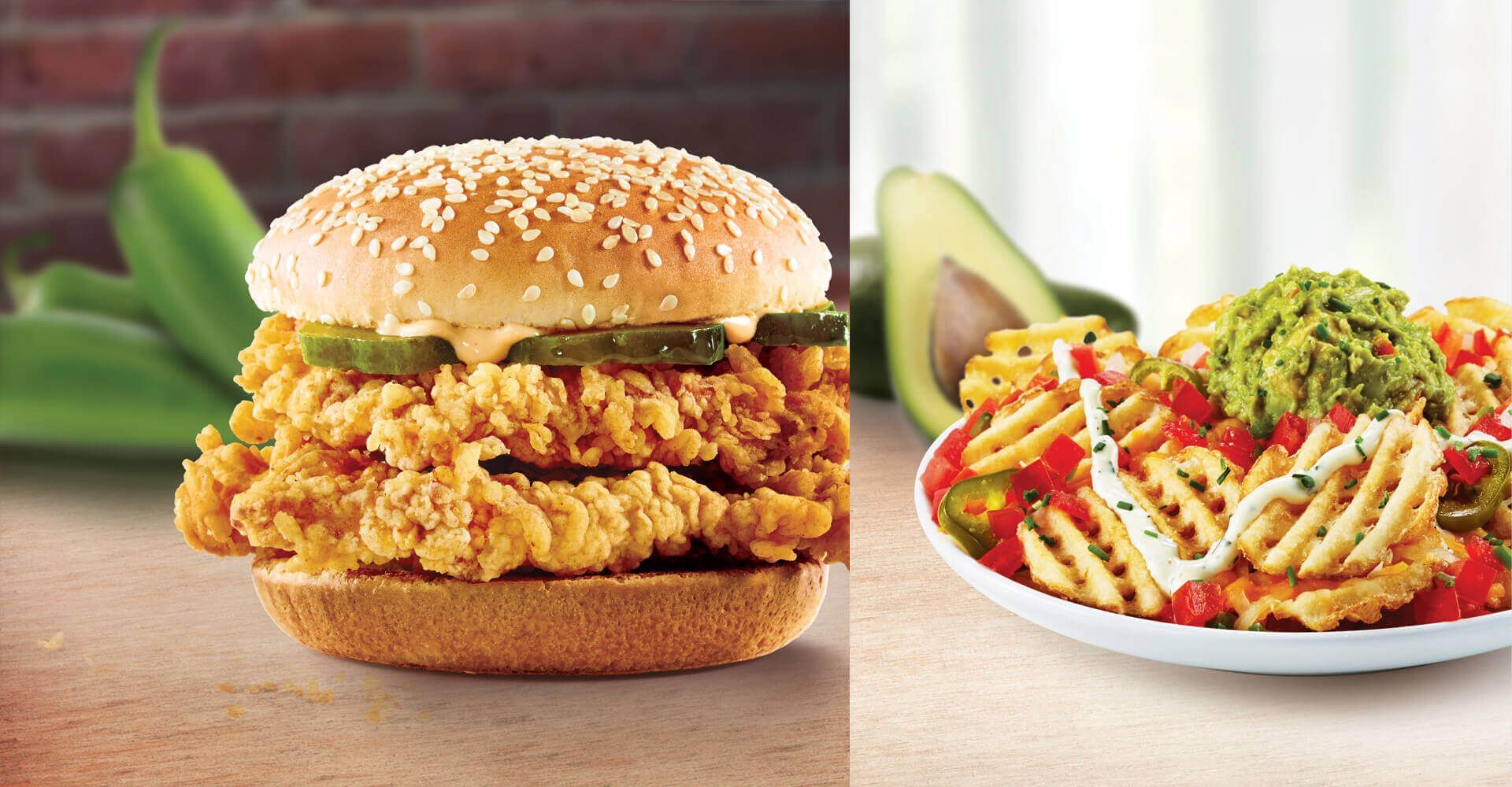 A chicken sandwich next to a plate of french fries