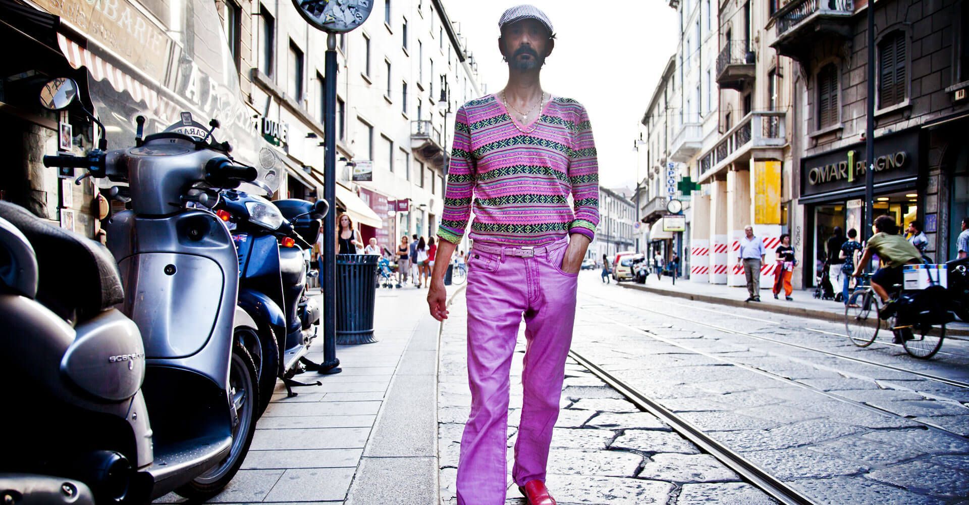 A man in pink pants is walking down a street