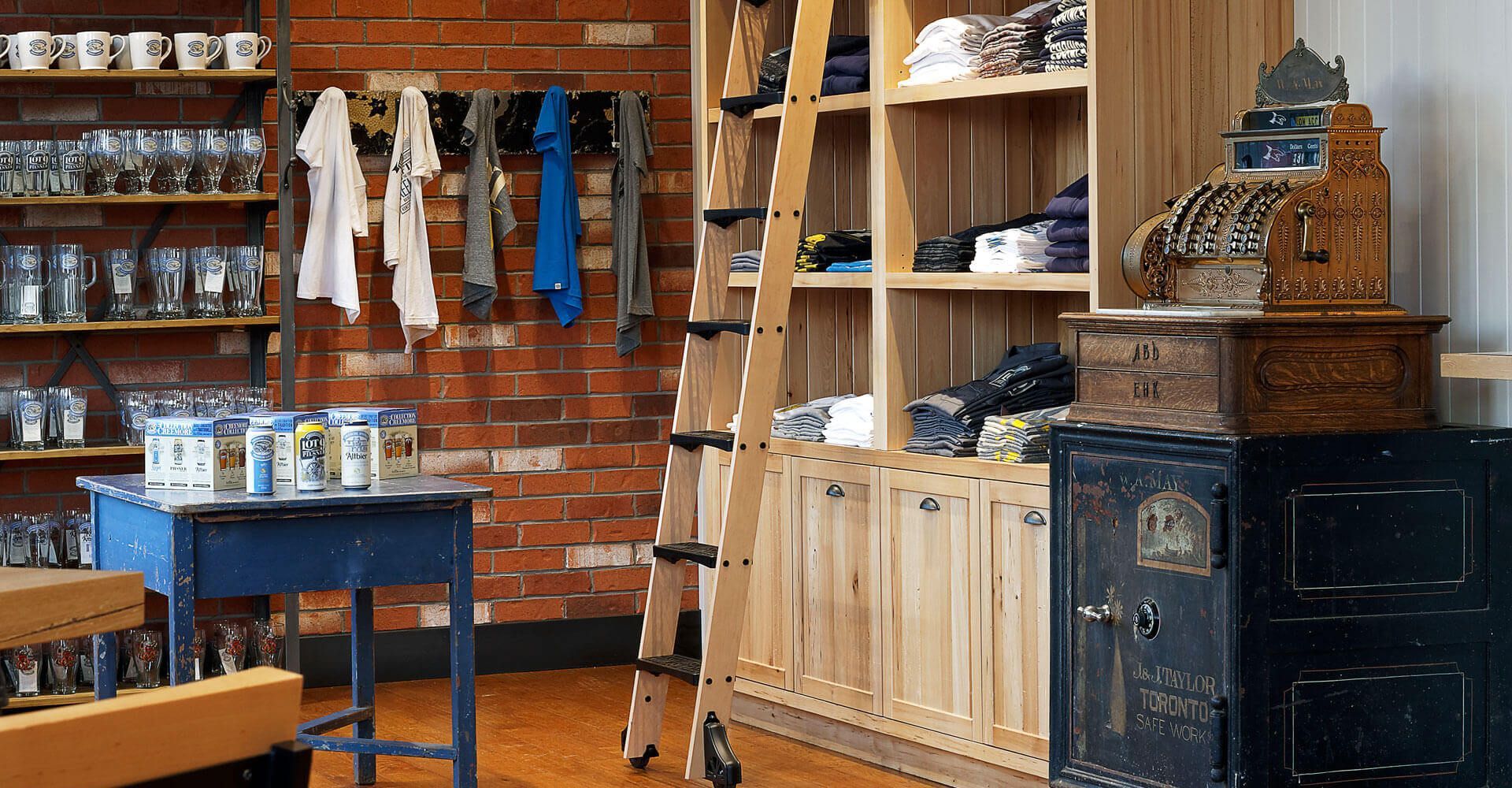 A store with a table , shelves , and a cash register.