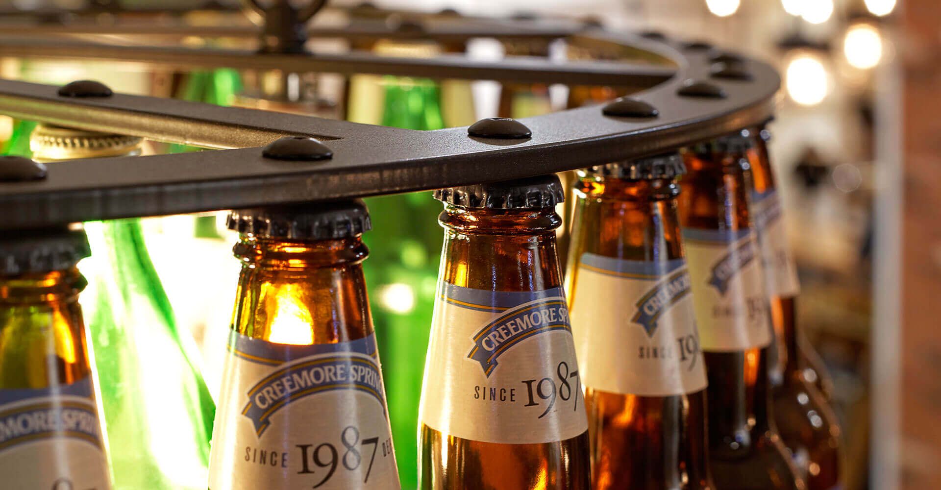 A row of beer bottles are lined up in a circle.