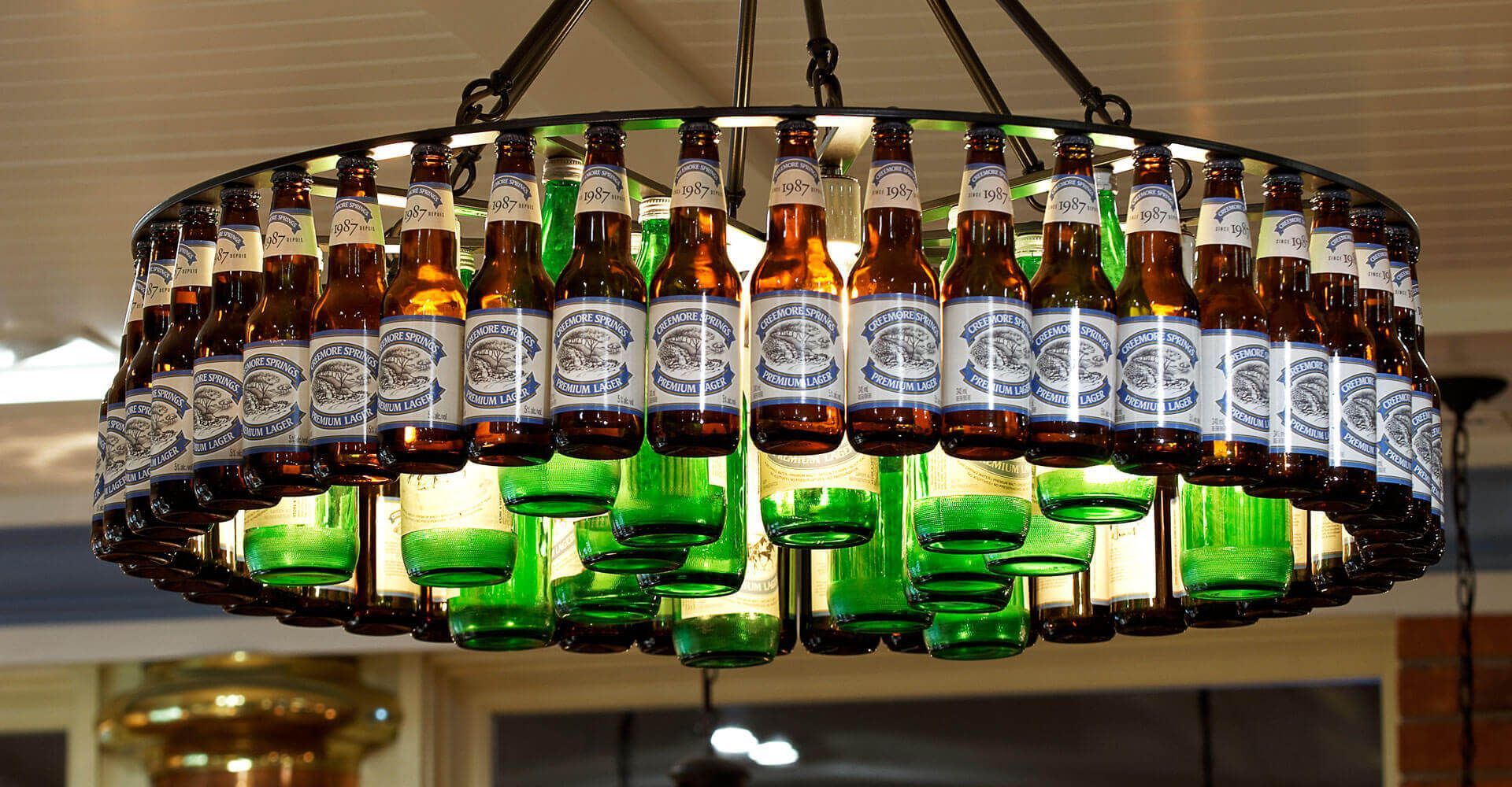 A chandelier made out of beer bottles hanging from the ceiling
