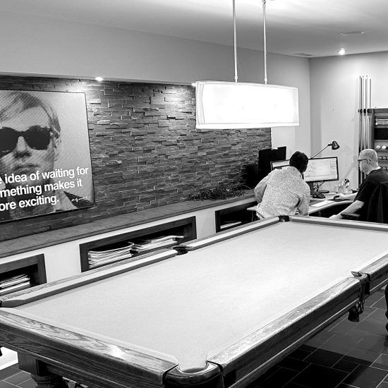 A black and white photo of a pool table in a living room.