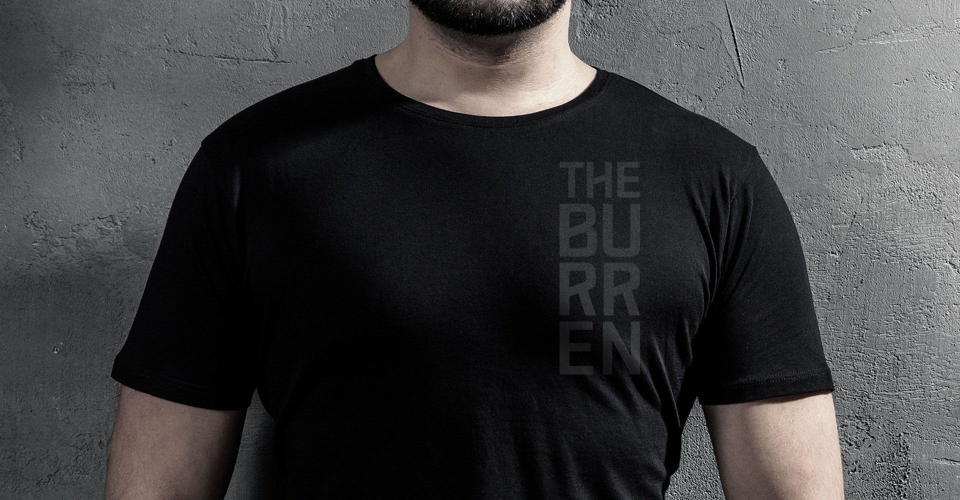 A man with a beard is wearing a black t-shirt.