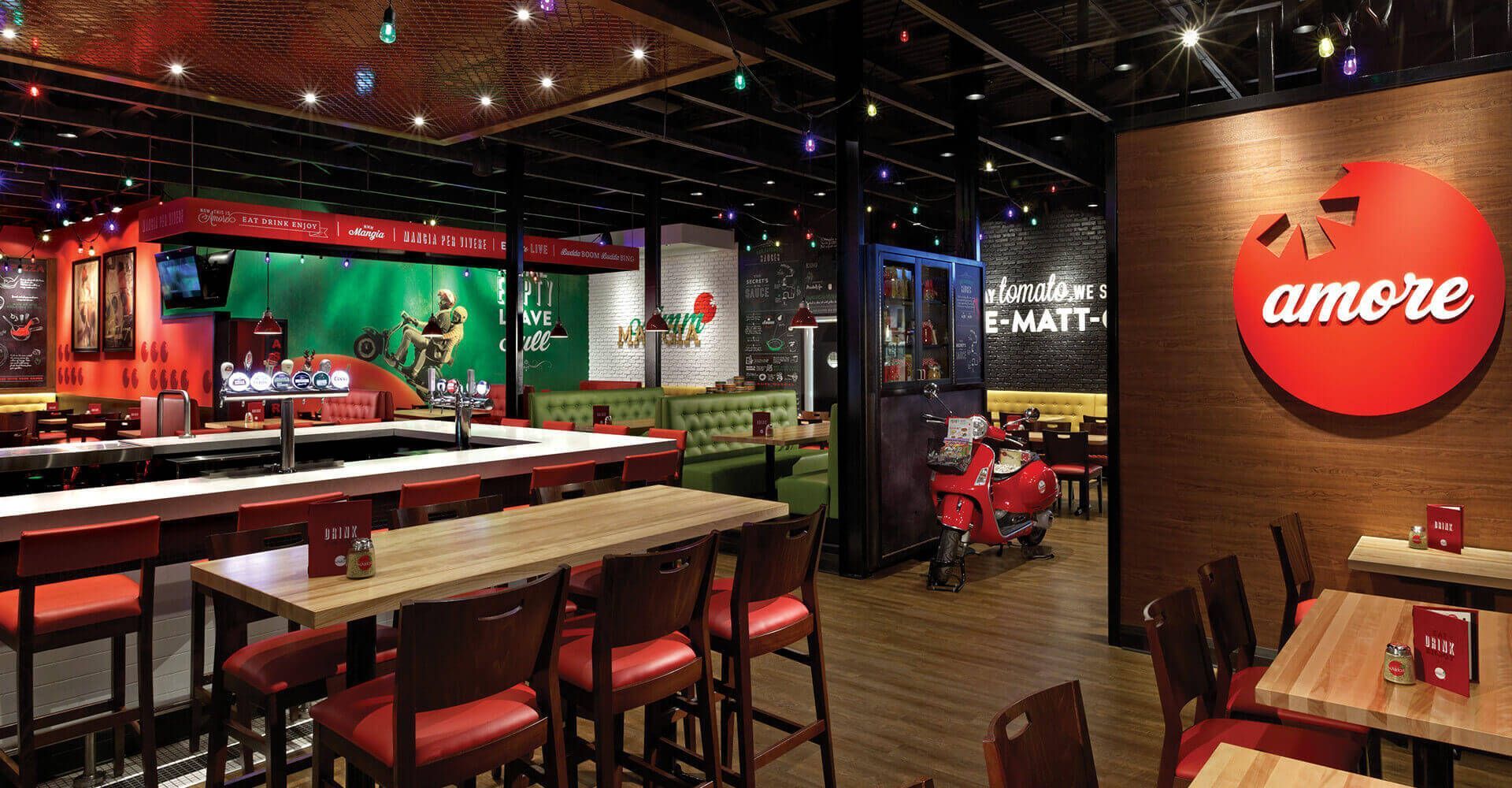 A restaurant with tables and chairs and a sign that says amore