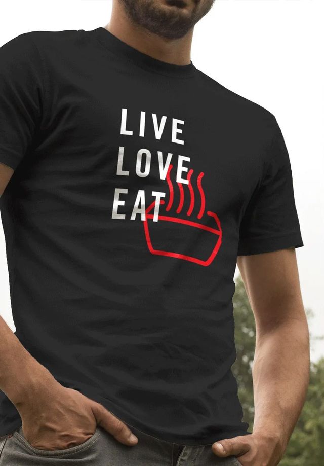 A man wearing a black t-shirt that says live love eat