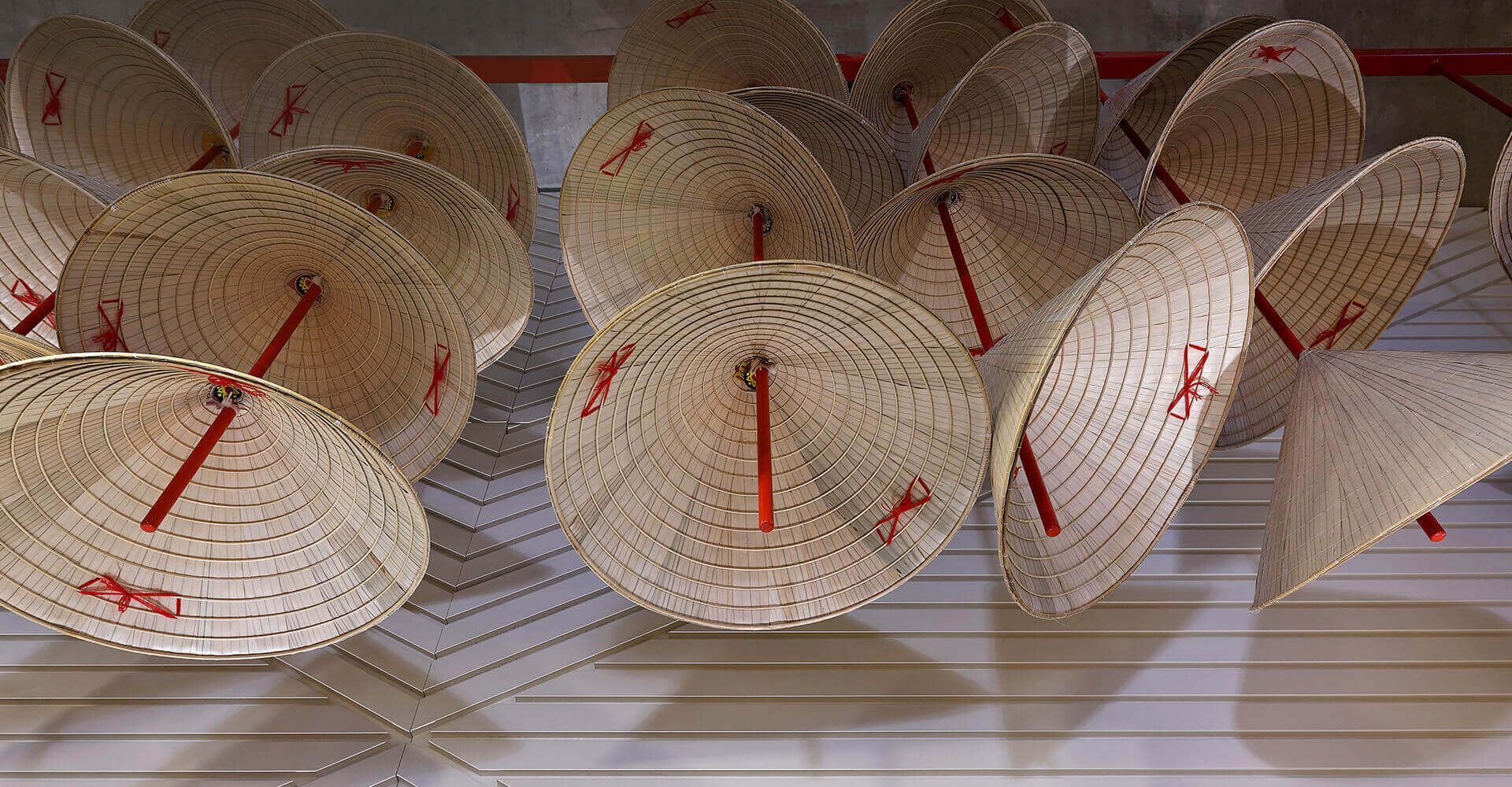 A bunch of straw hats are hanging on a wall.