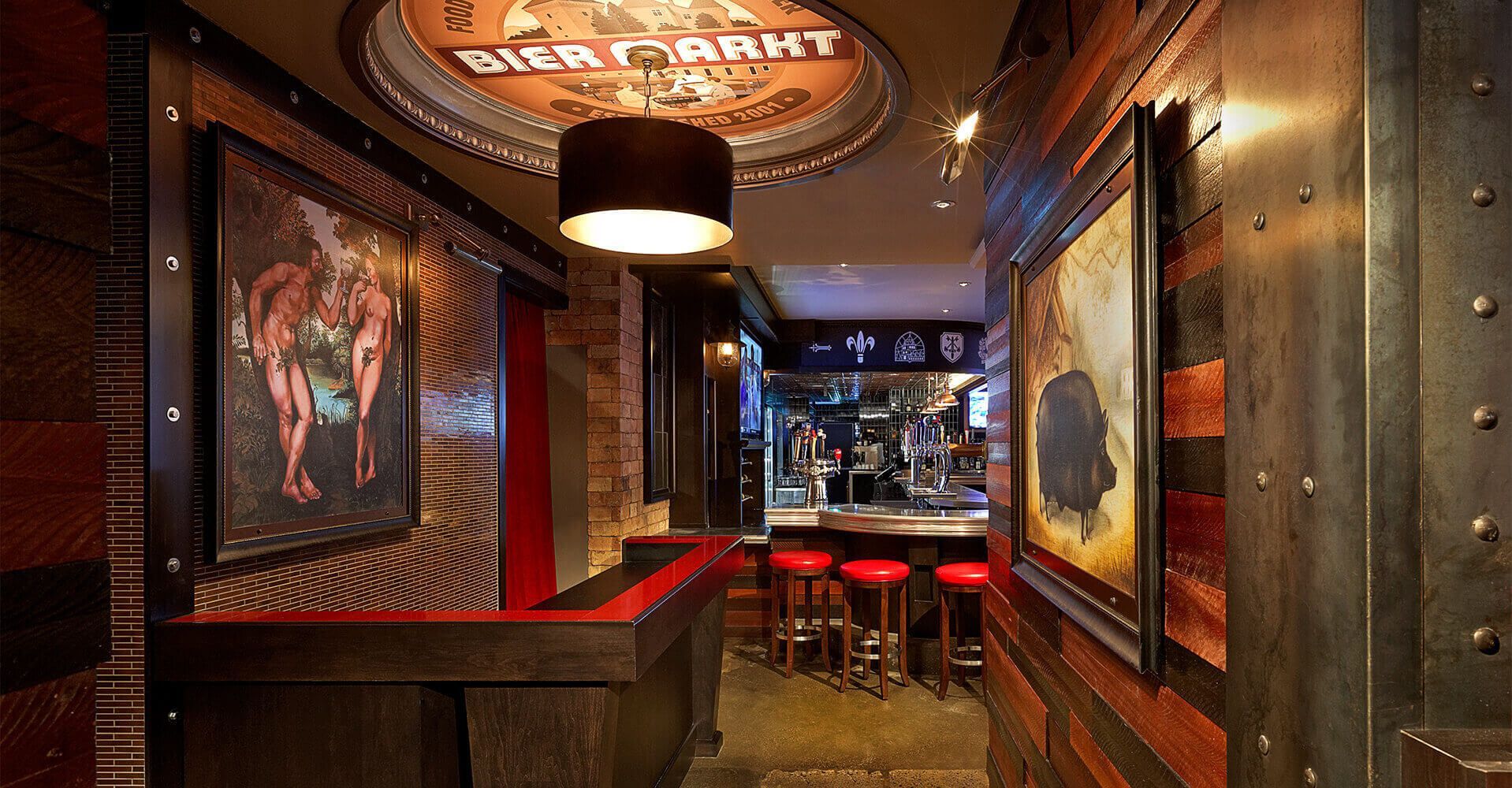 A hallway leading to a restaurant with a sign on the ceiling that says ' sick barn '