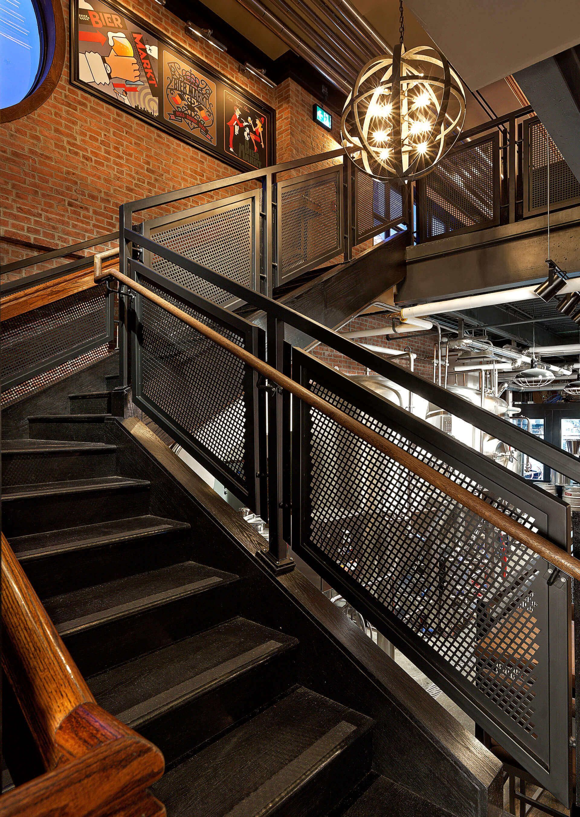 A staircase with a metal railing and a wooden handrail