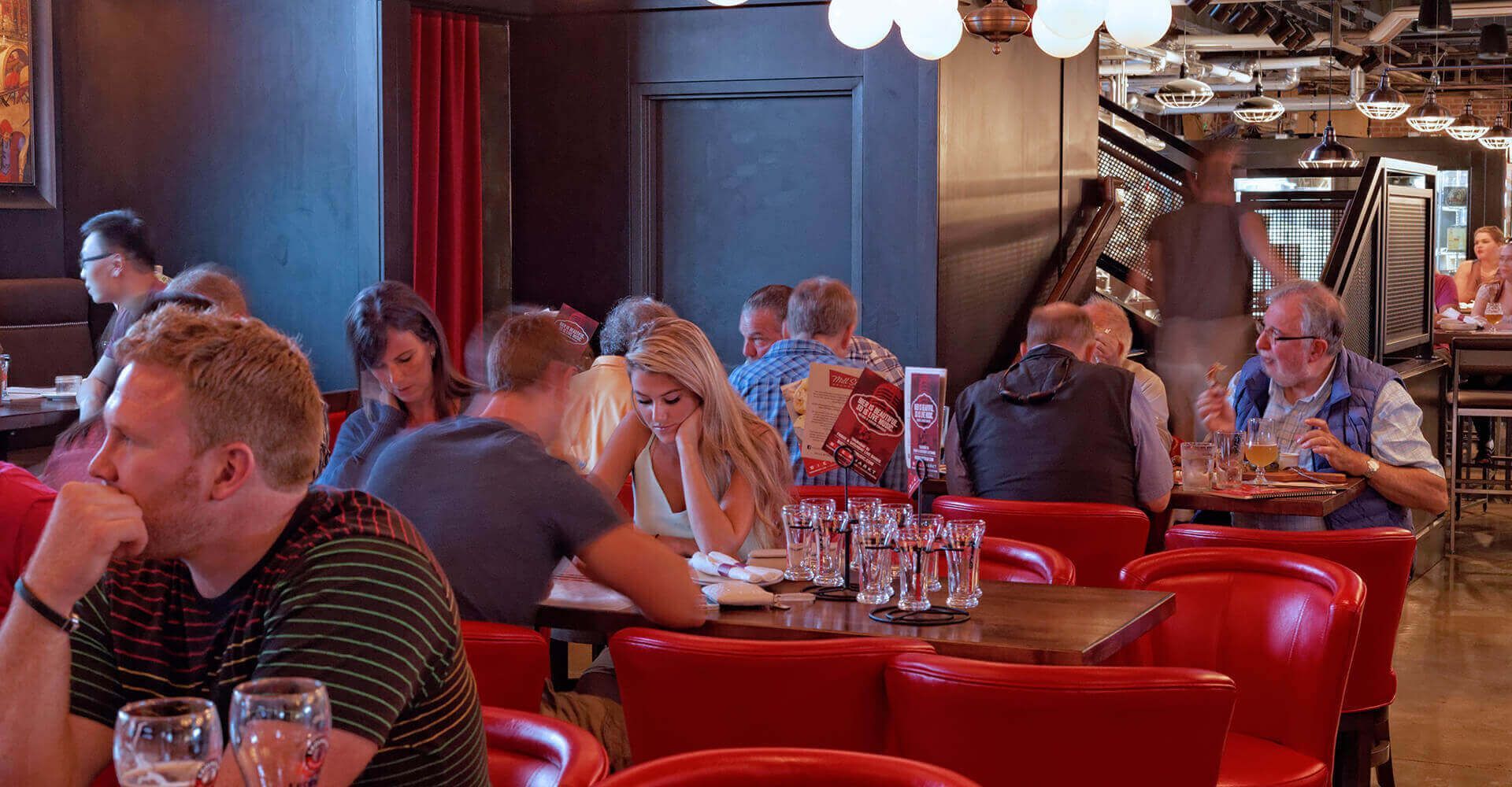 A group of people are sitting at tables in a restaurant.