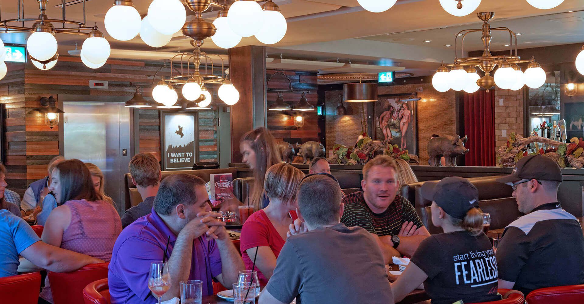 A group of people are sitting at tables in a restaurant.