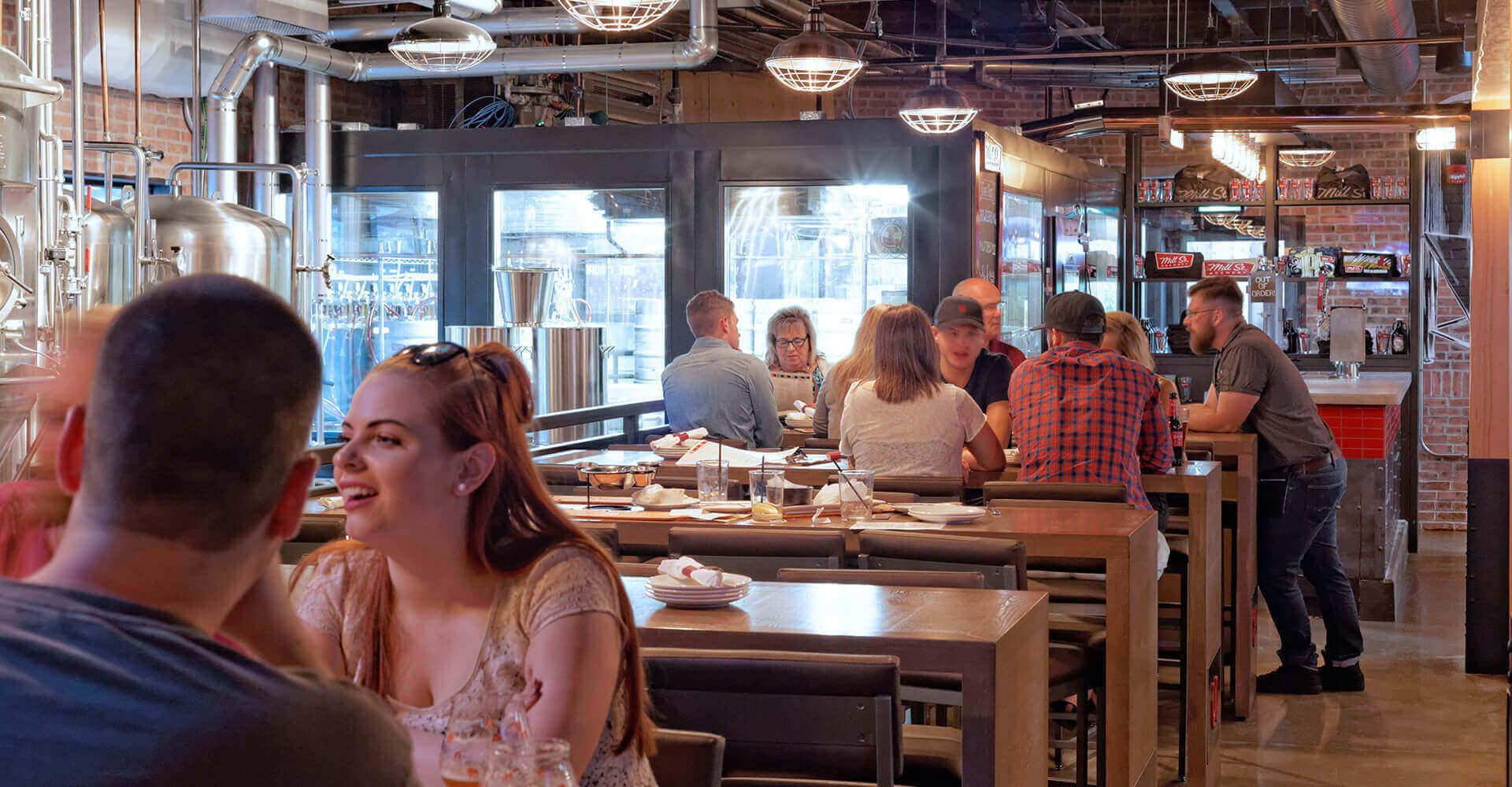 A group of people are sitting at tables in a restaurant.