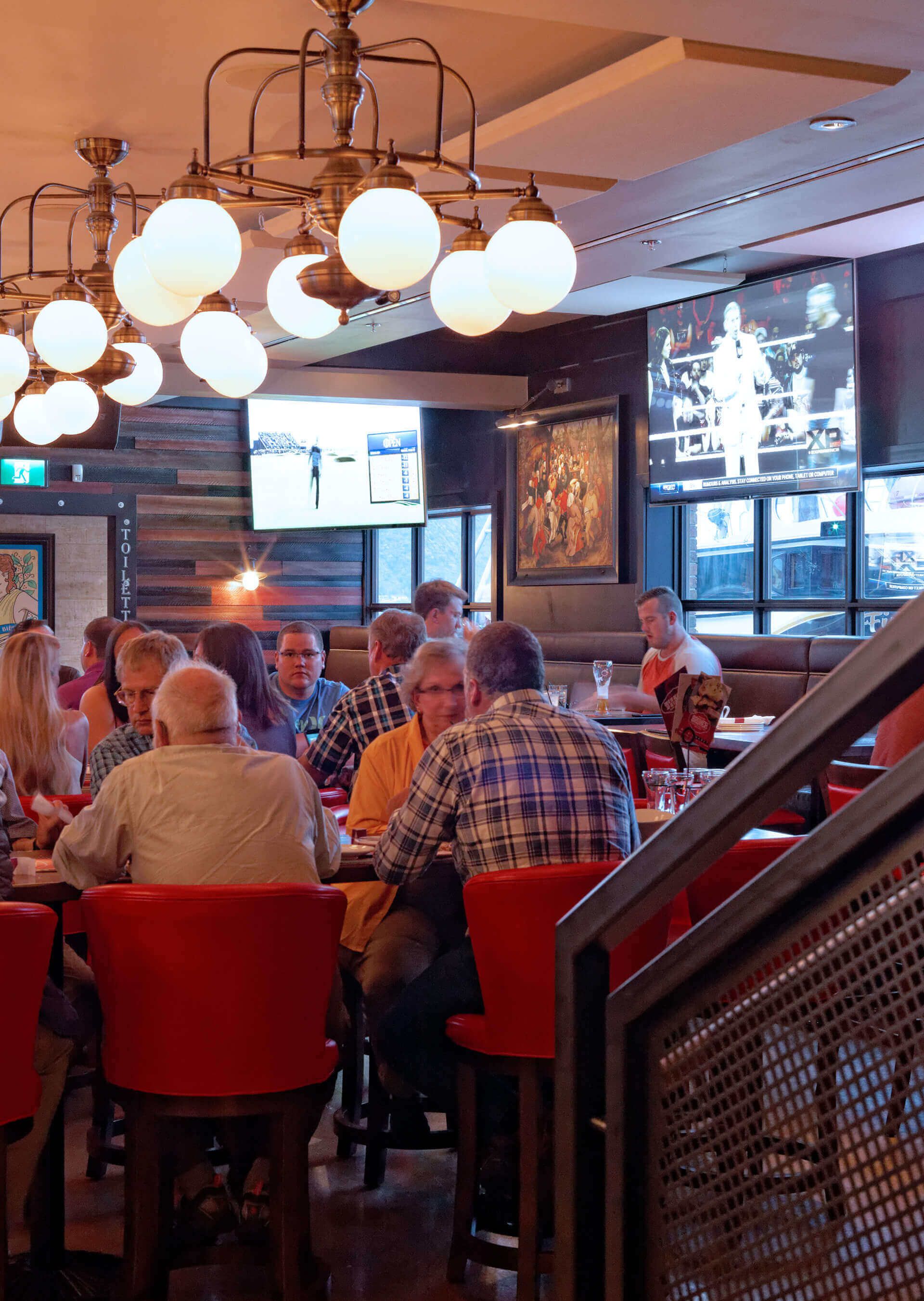 A group of people are sitting at tables in a restaurant.