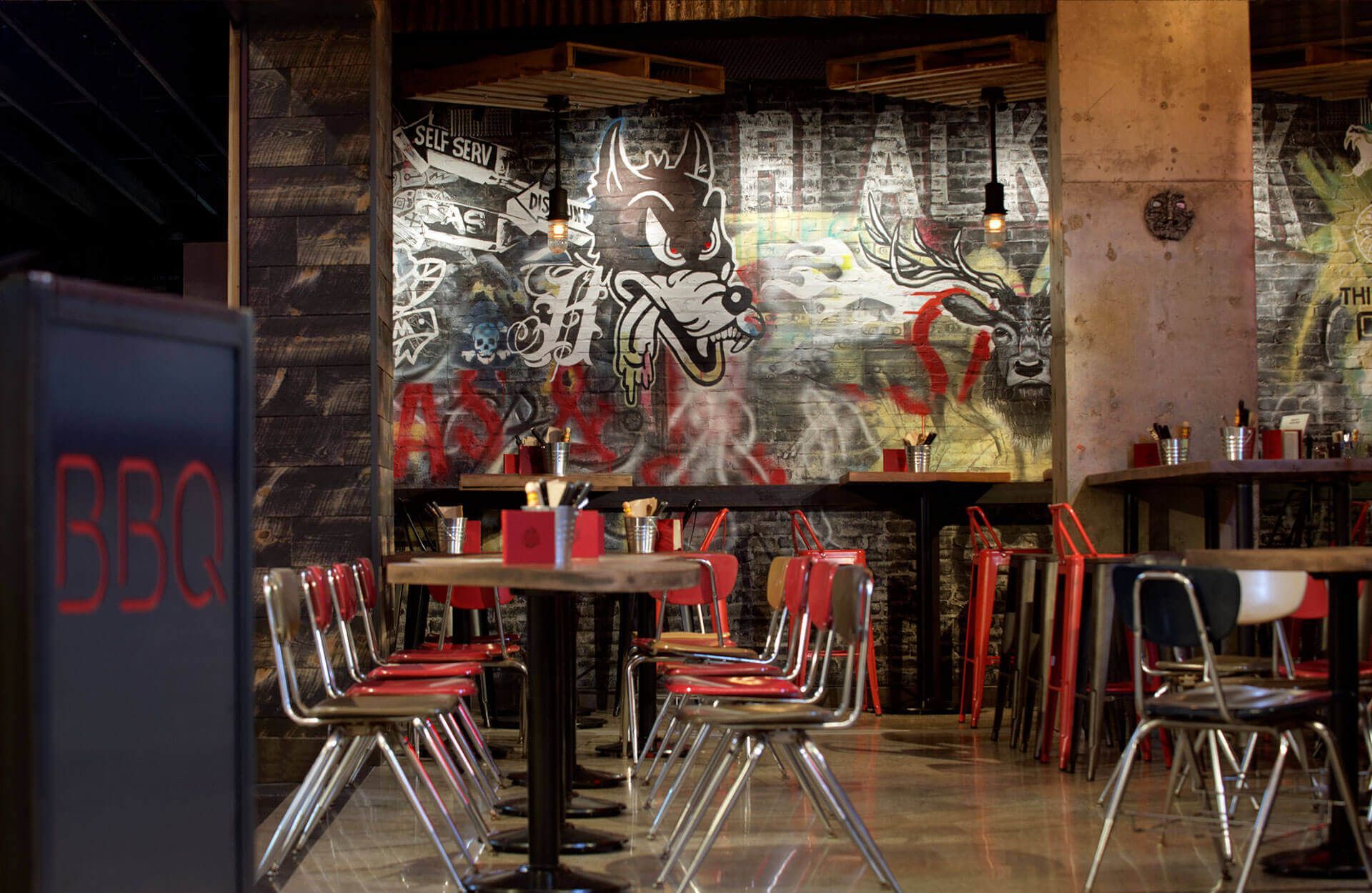 A restaurant with tables and chairs and a sign that says bbc