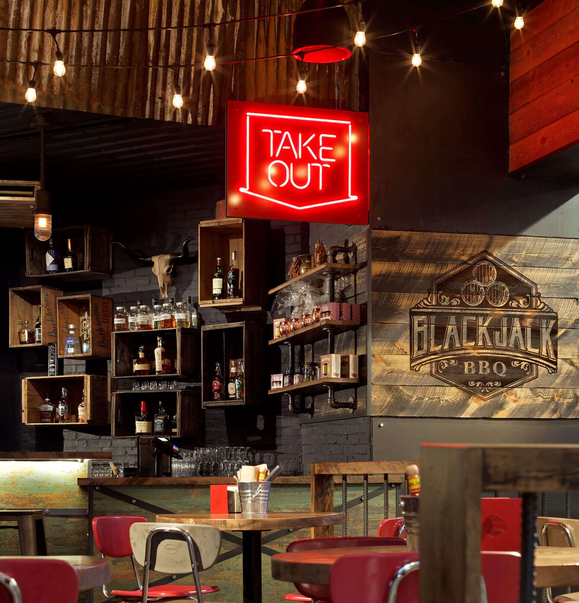 A restaurant with a neon sign that says take out