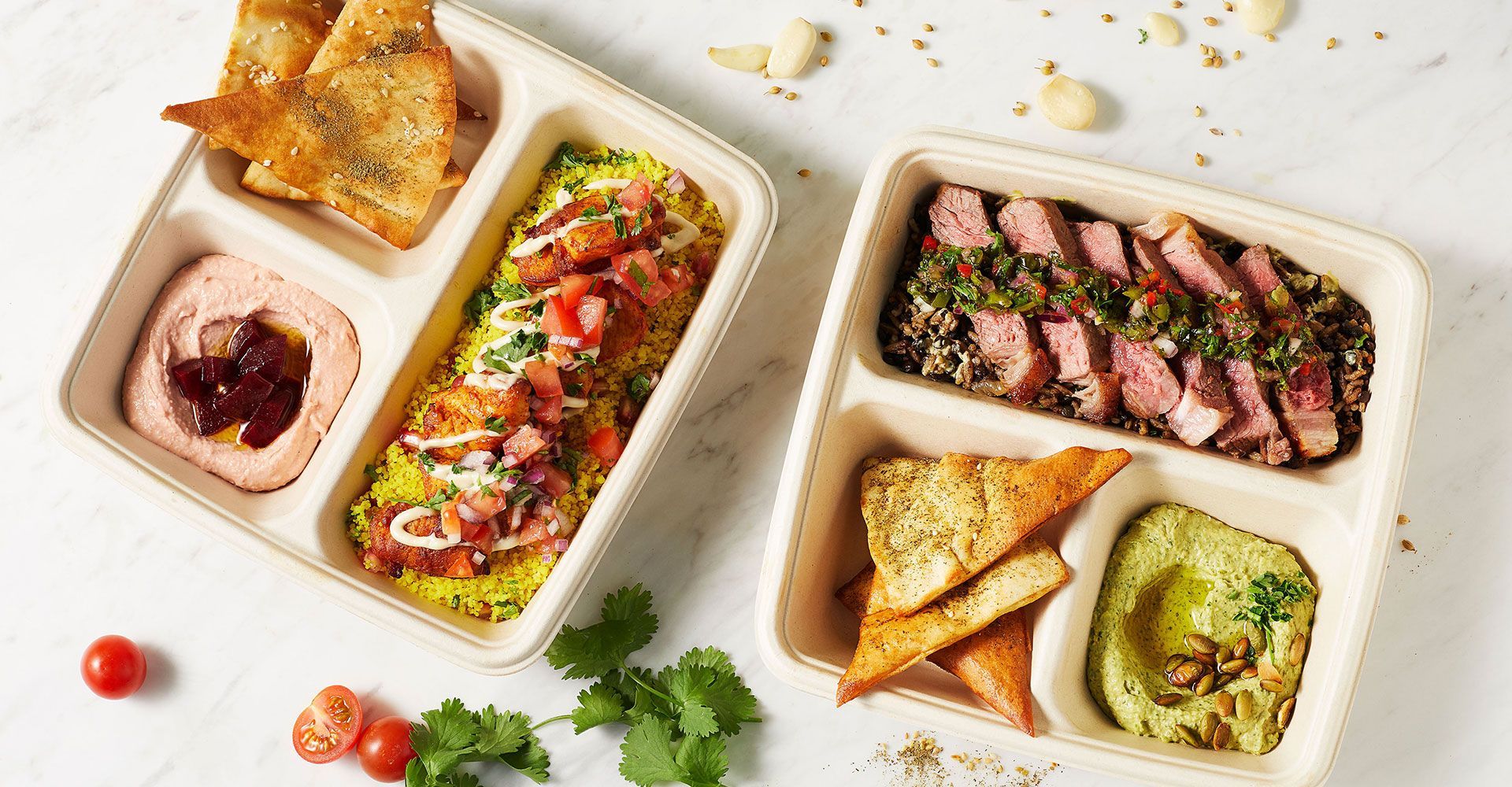 Two trays filled with different types of food are sitting on a table.