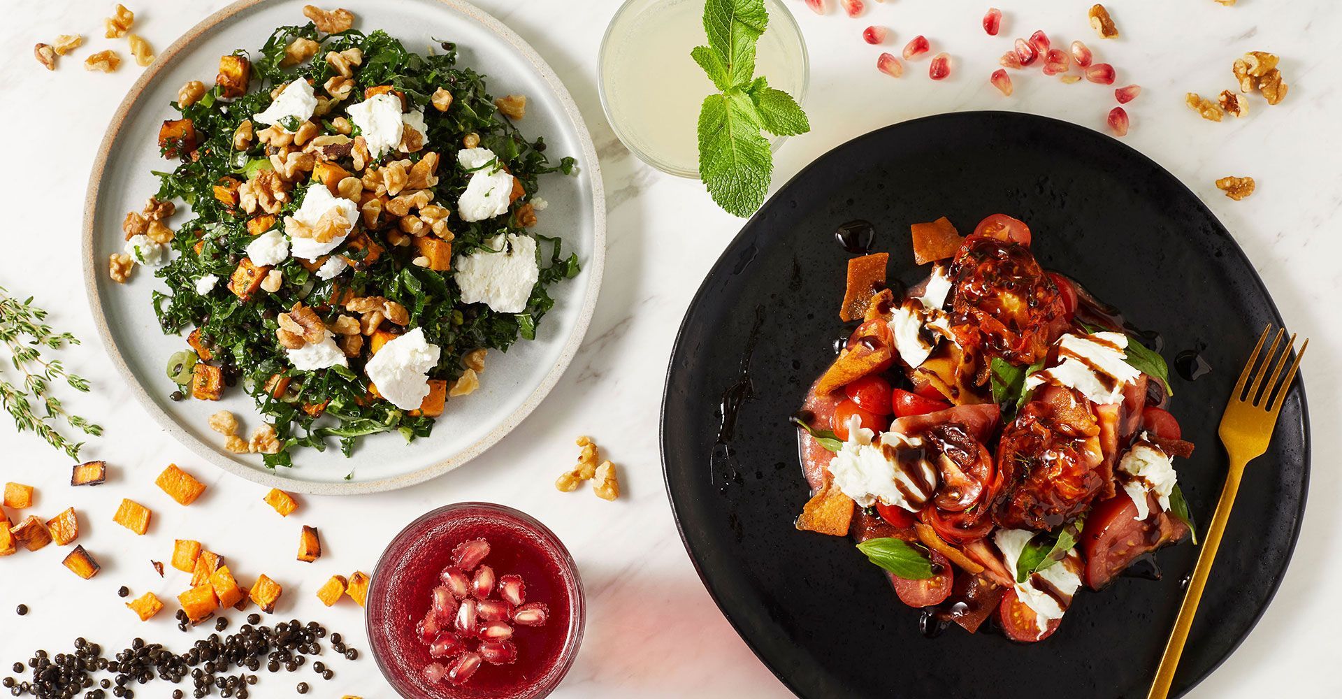 There are two plates of food on the table , one of which is a salad.