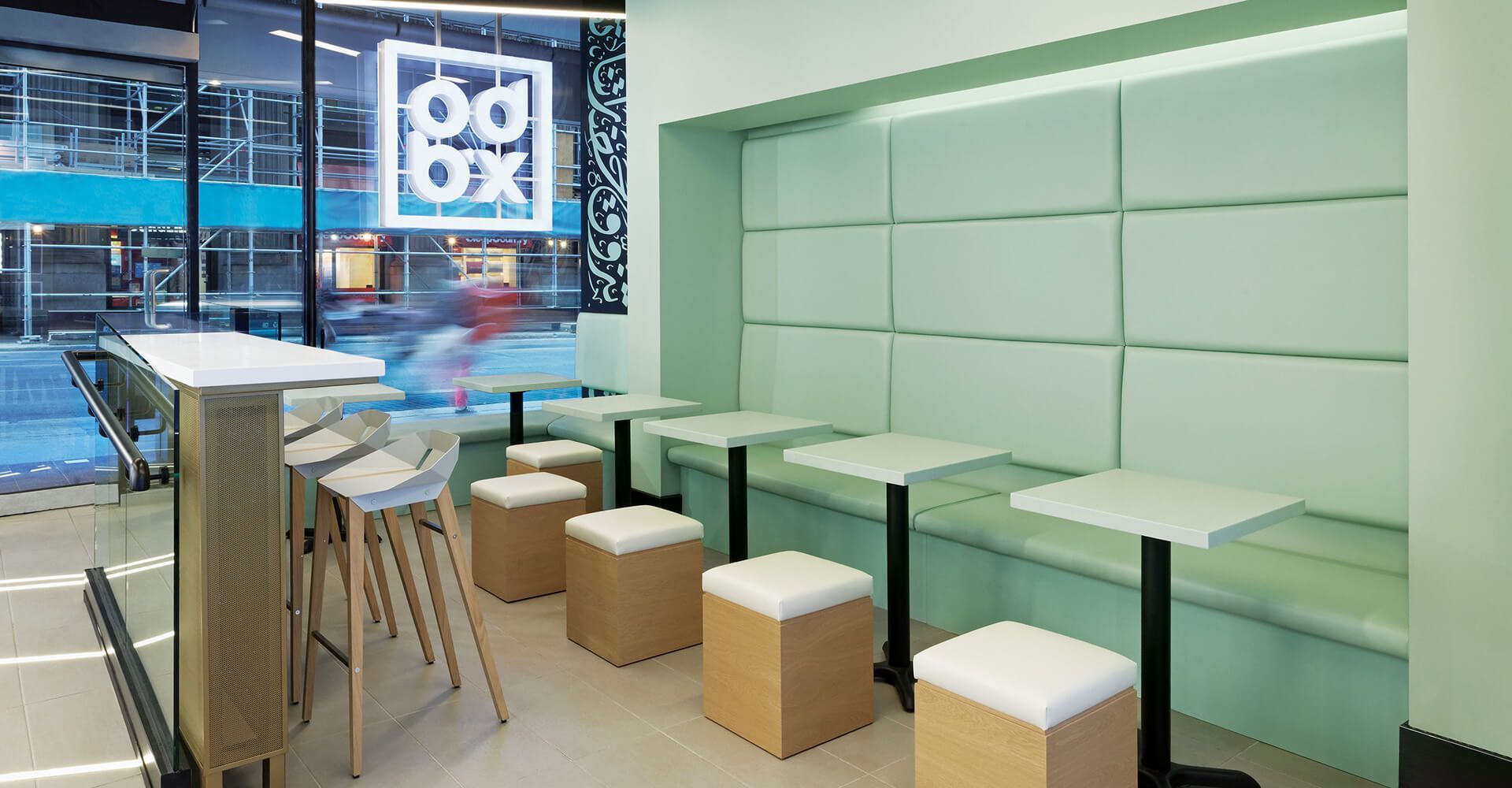 A restaurant with tables and stools and a sign that says food box