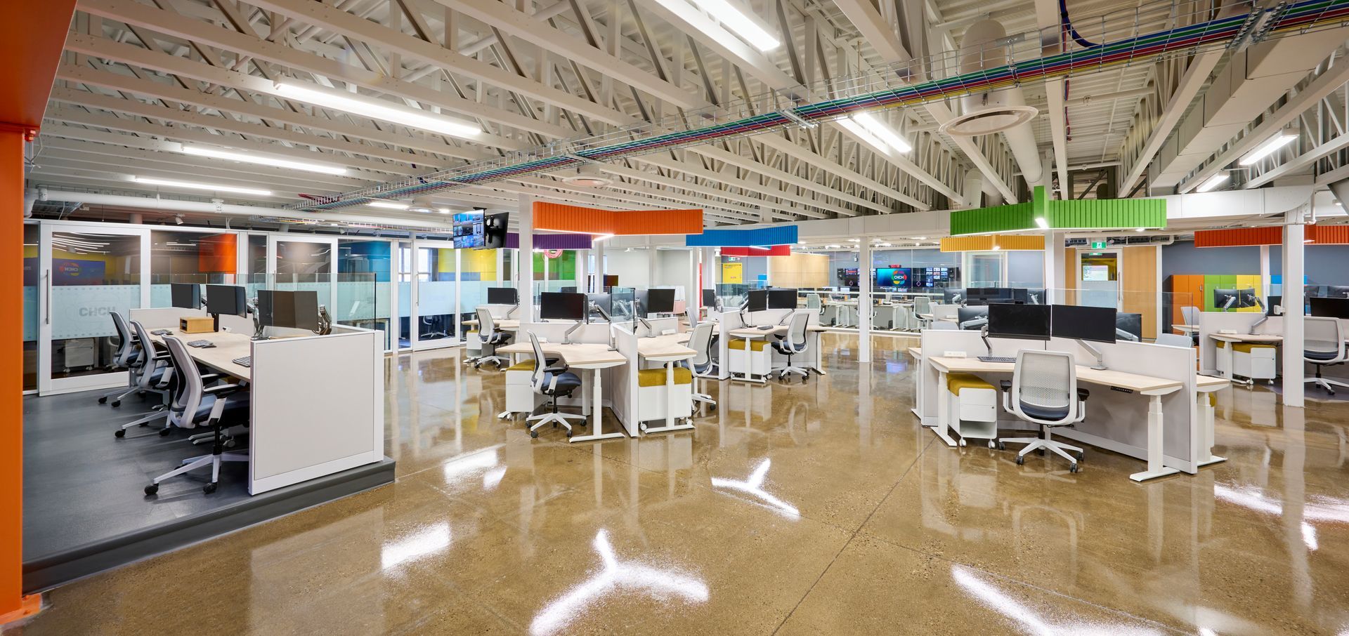 A large open office with lots of desks and chairs.
