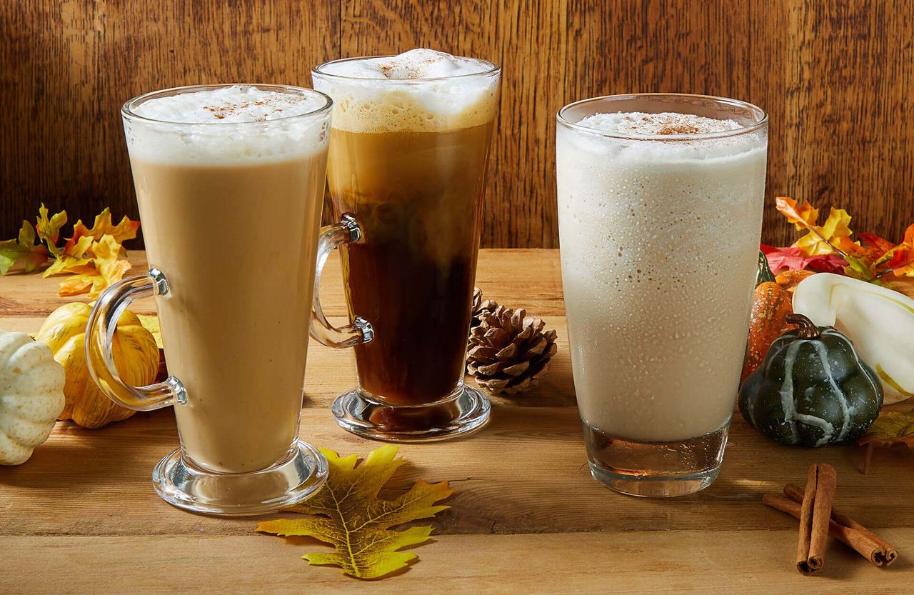 Three different types of drinks are sitting on a wooden table.