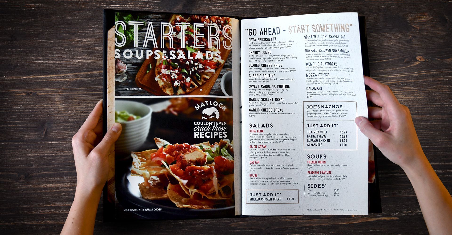 A person is holding a menu that says starters soups and salads