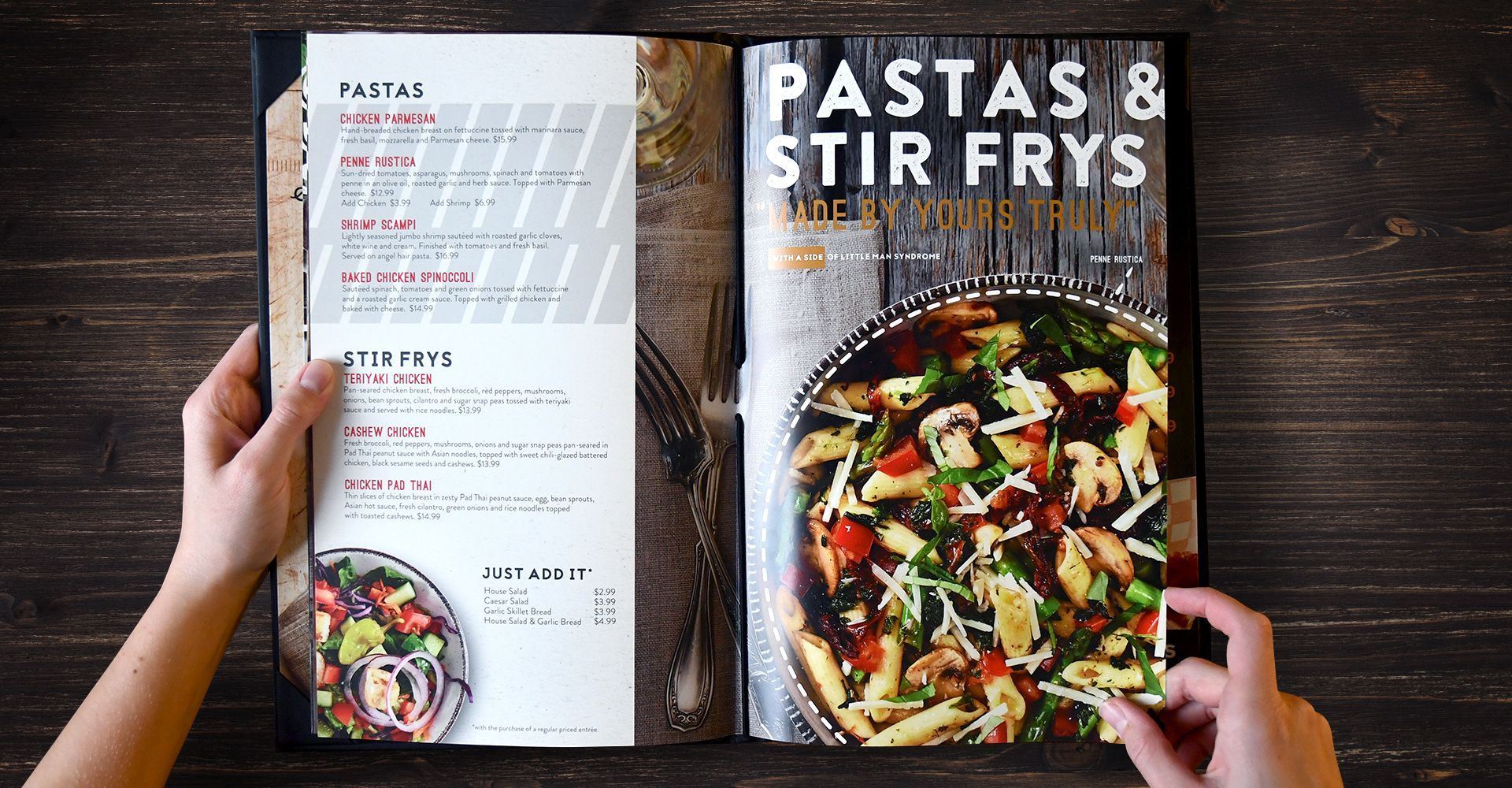 A person is holding a book open to a page that says pastas & stir frys