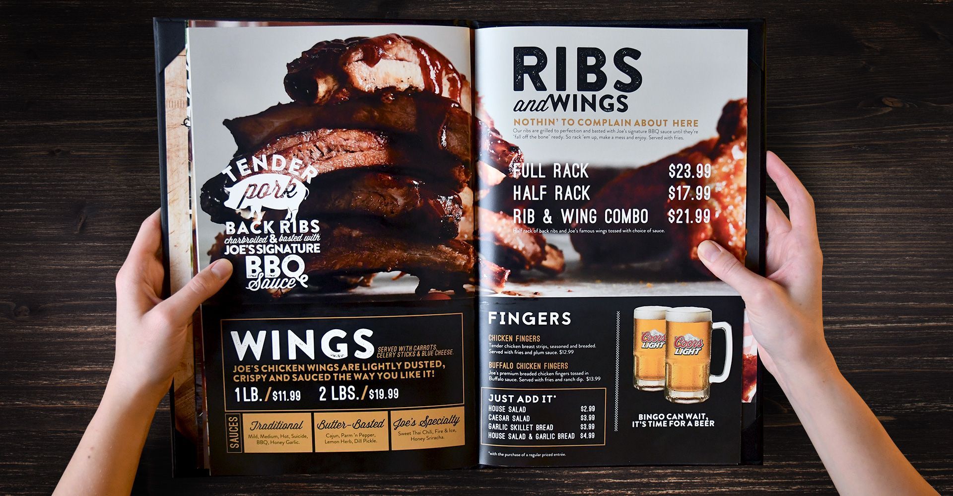 A person is holding a menu for ribs and wings