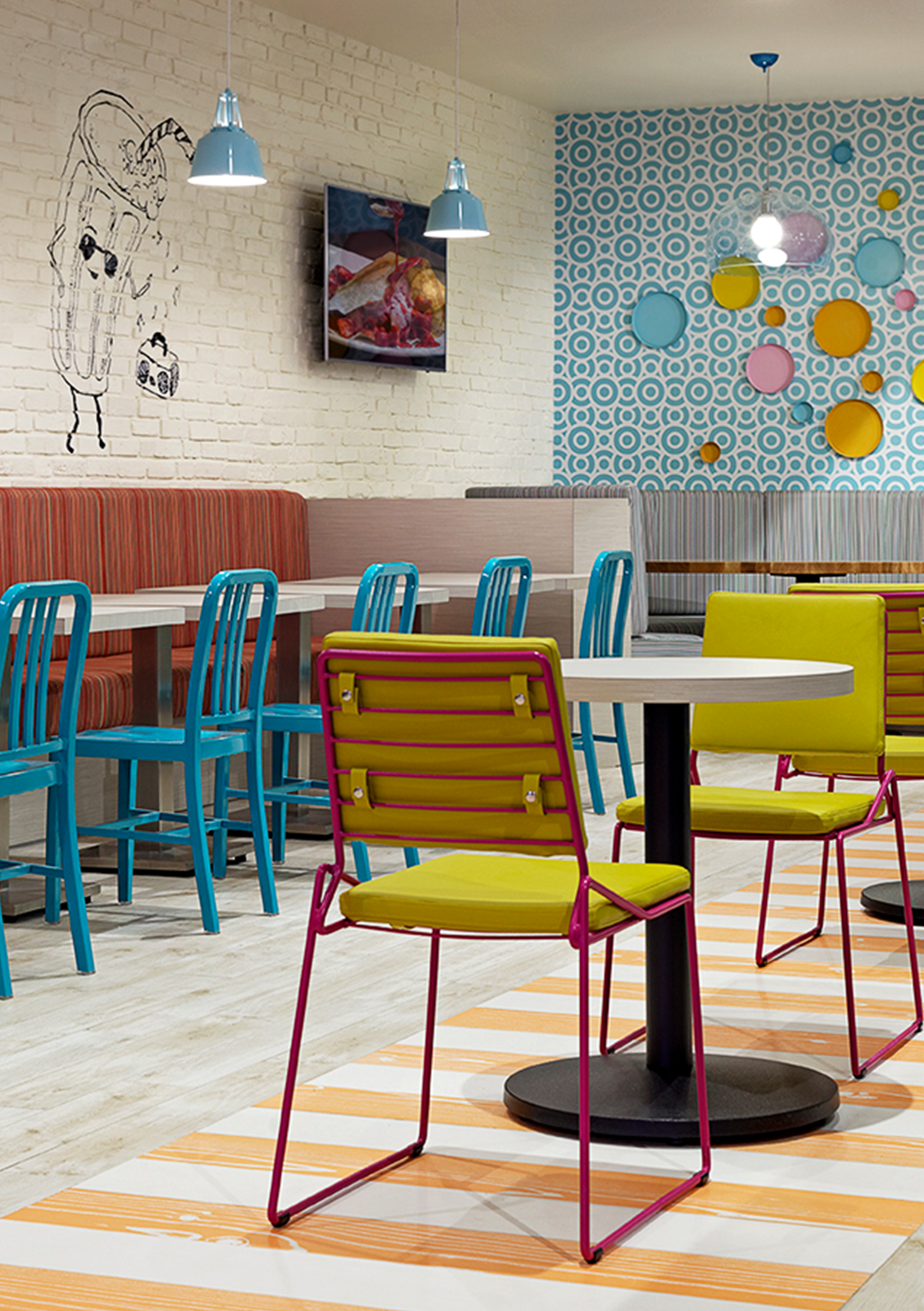A restaurant with tables and chairs and a painting on the wall
