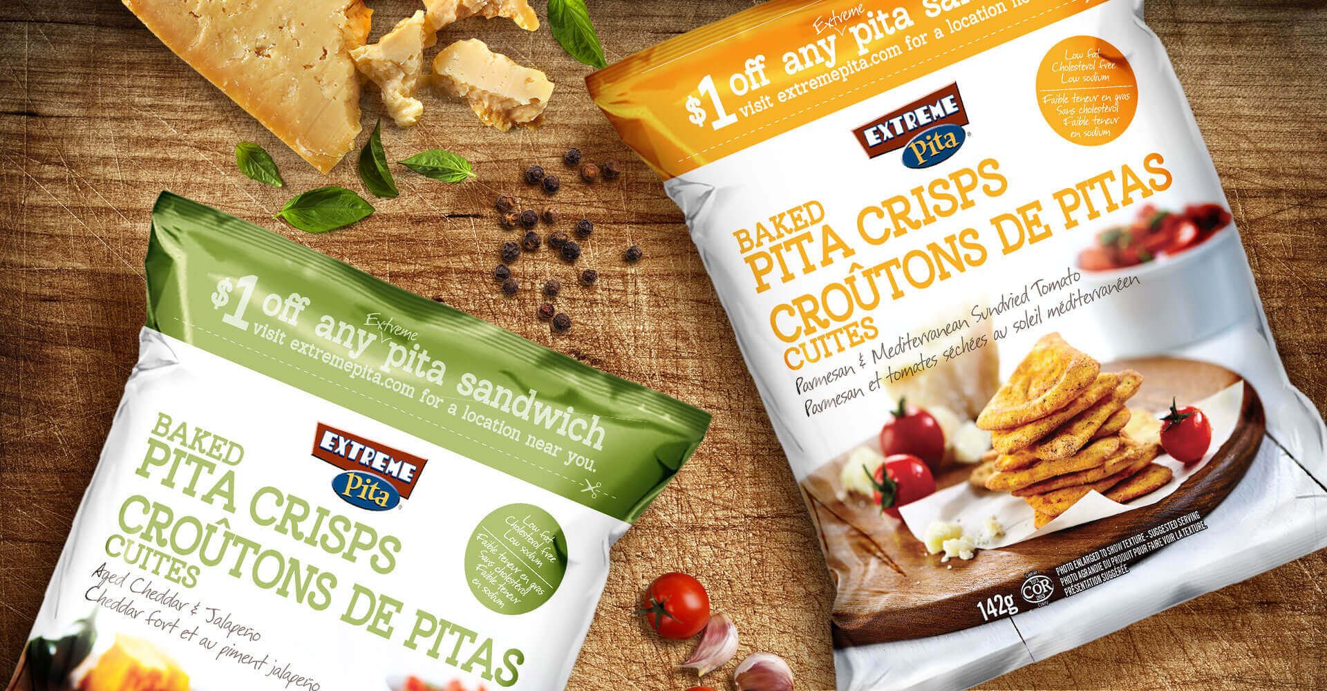 Two bags of pita crisps are sitting on a wooden table.