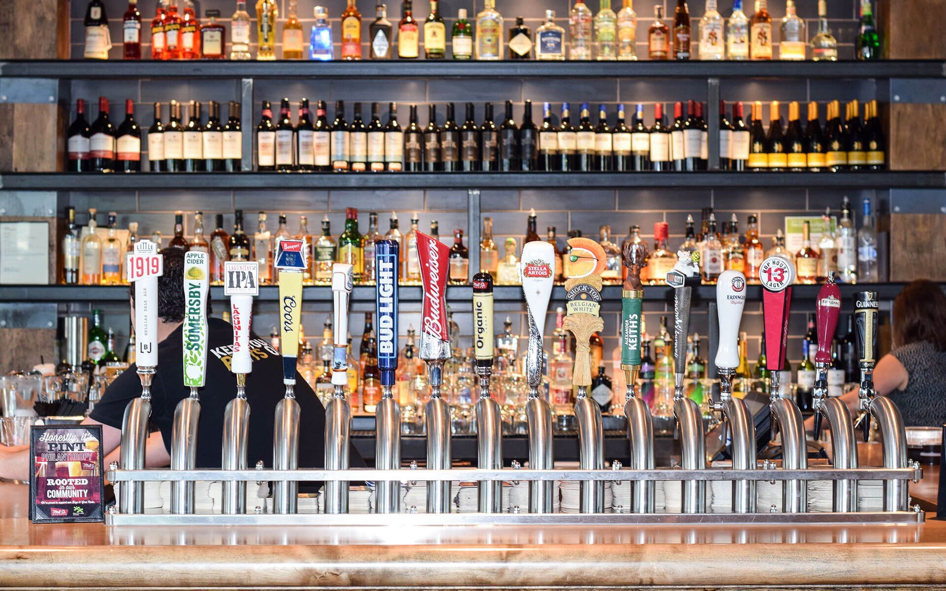 A bar filled with lots of beer taps and bottles