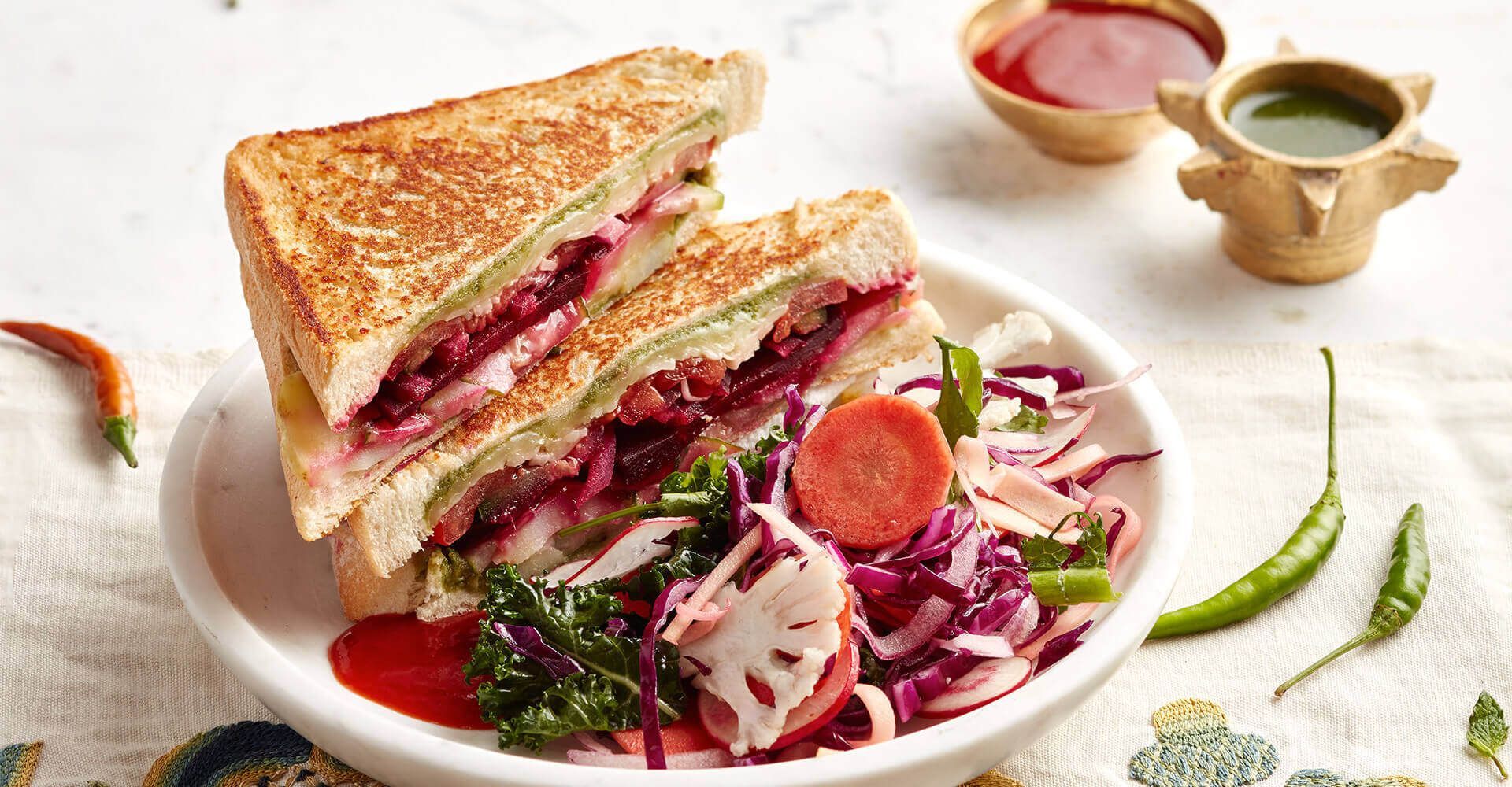 A sandwich and a salad on a plate on a table.