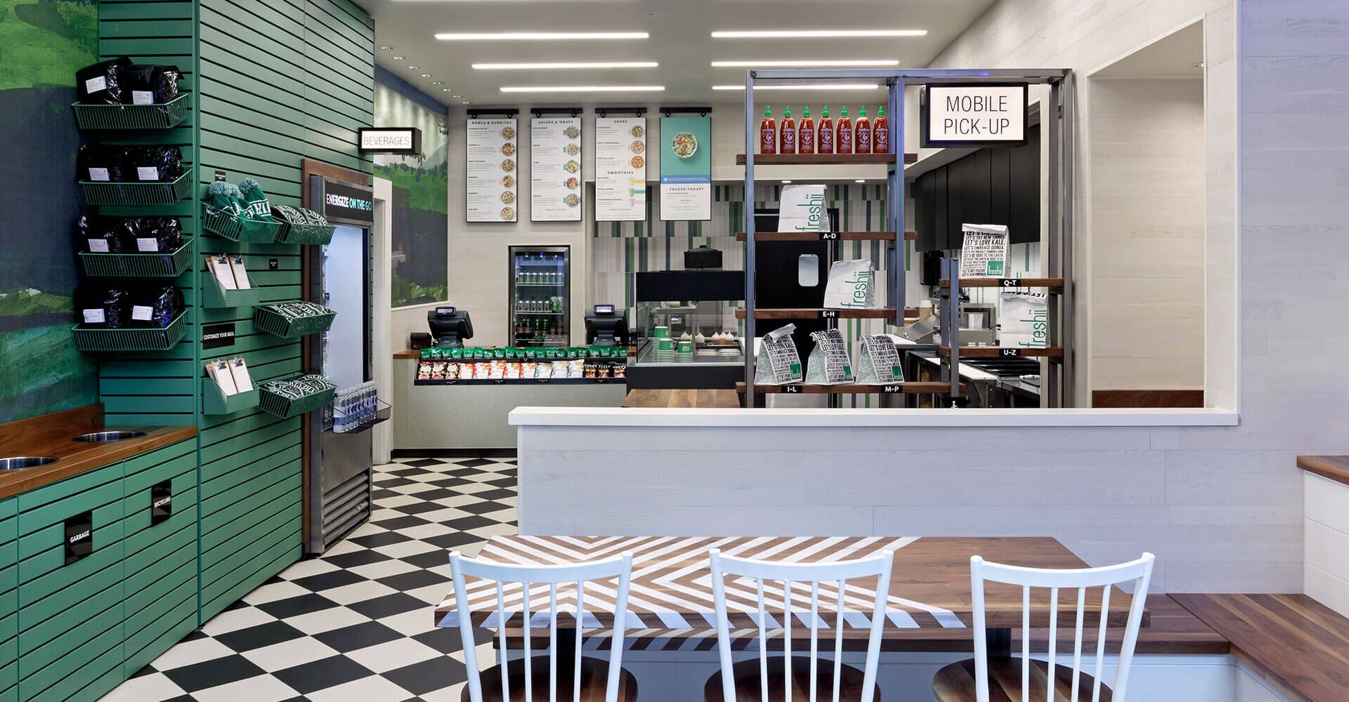 A restaurant with a checkered floor and tables and chairs.