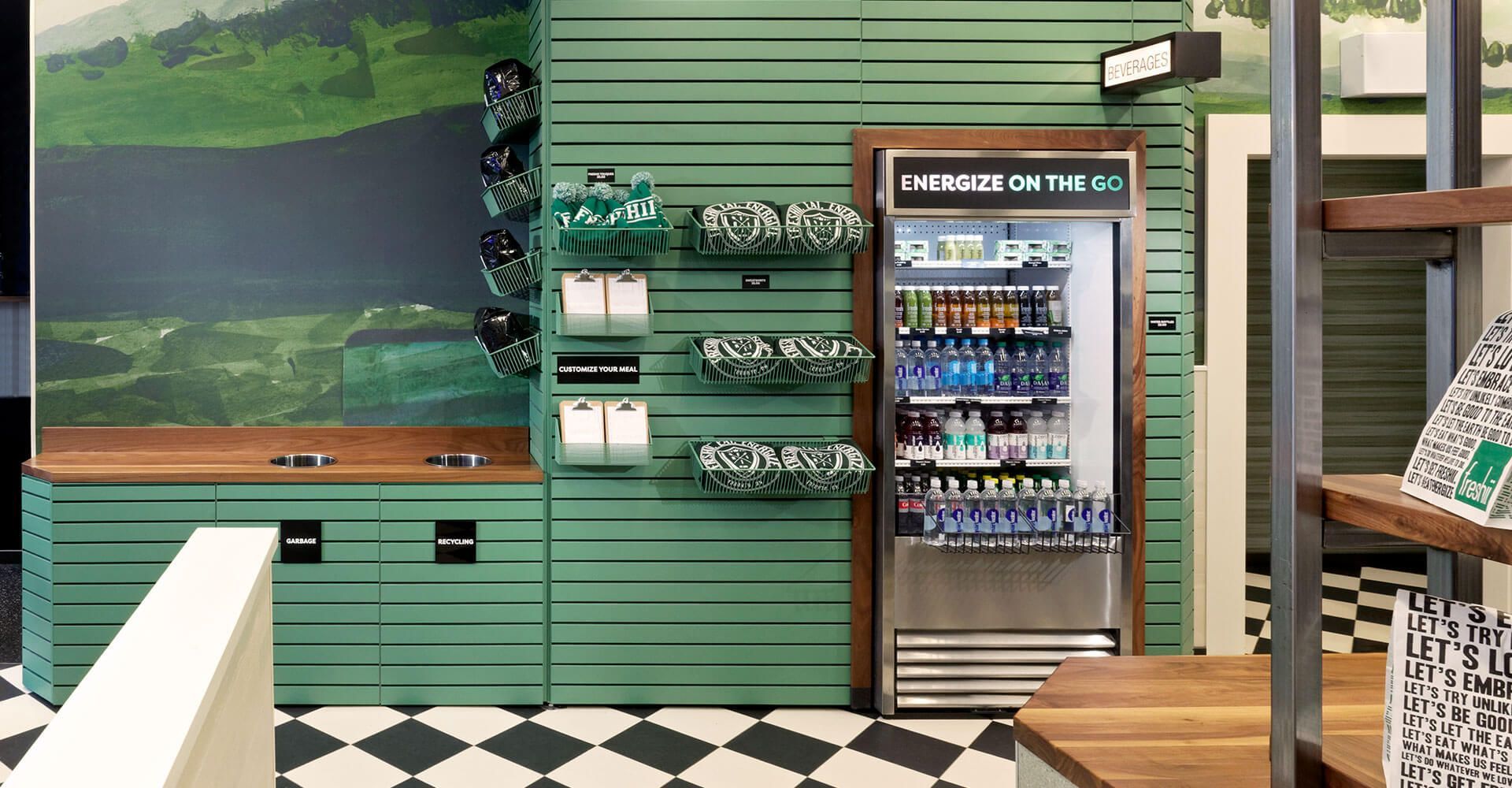 A kitchen with green cabinets , a fridge and a checkered floor.
