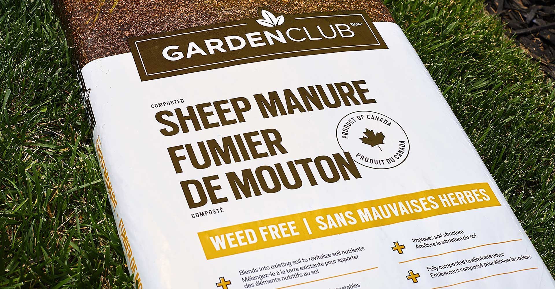 A bag of sheep manure is sitting on top of a lush green field.
