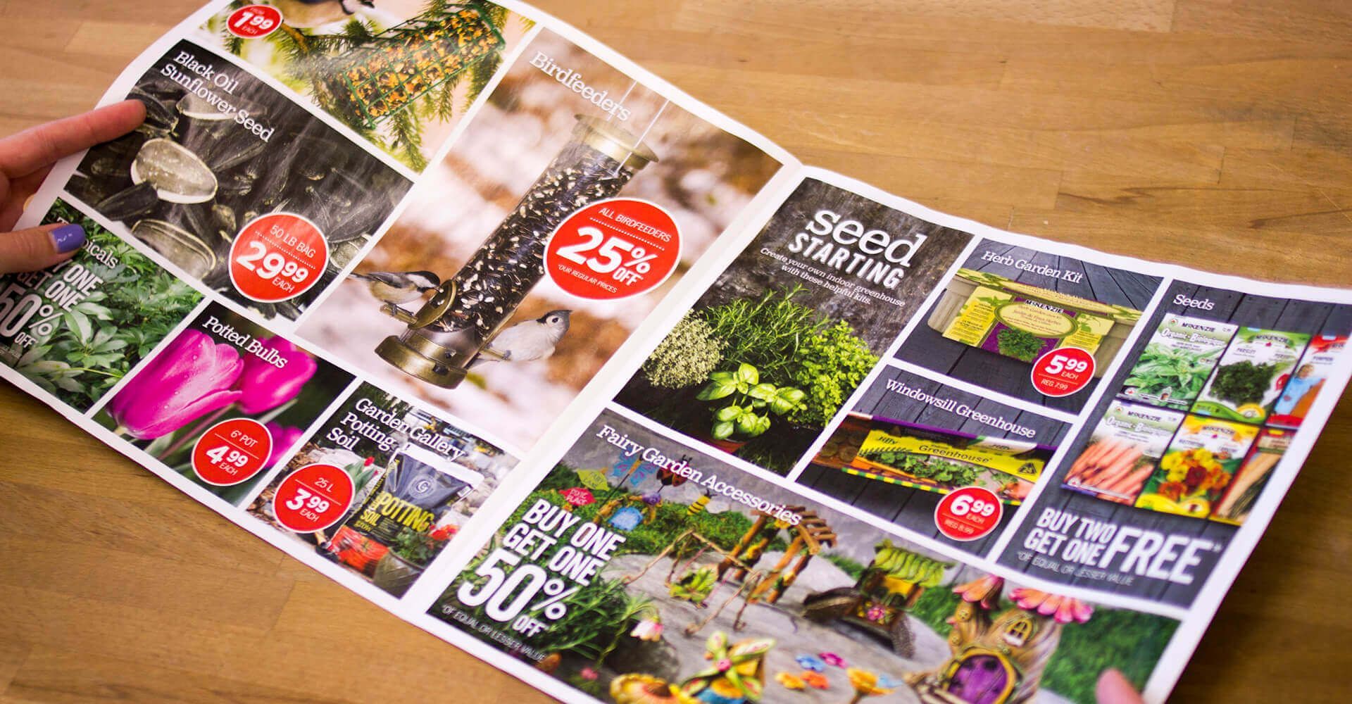 A person is holding a brochure on a wooden table.